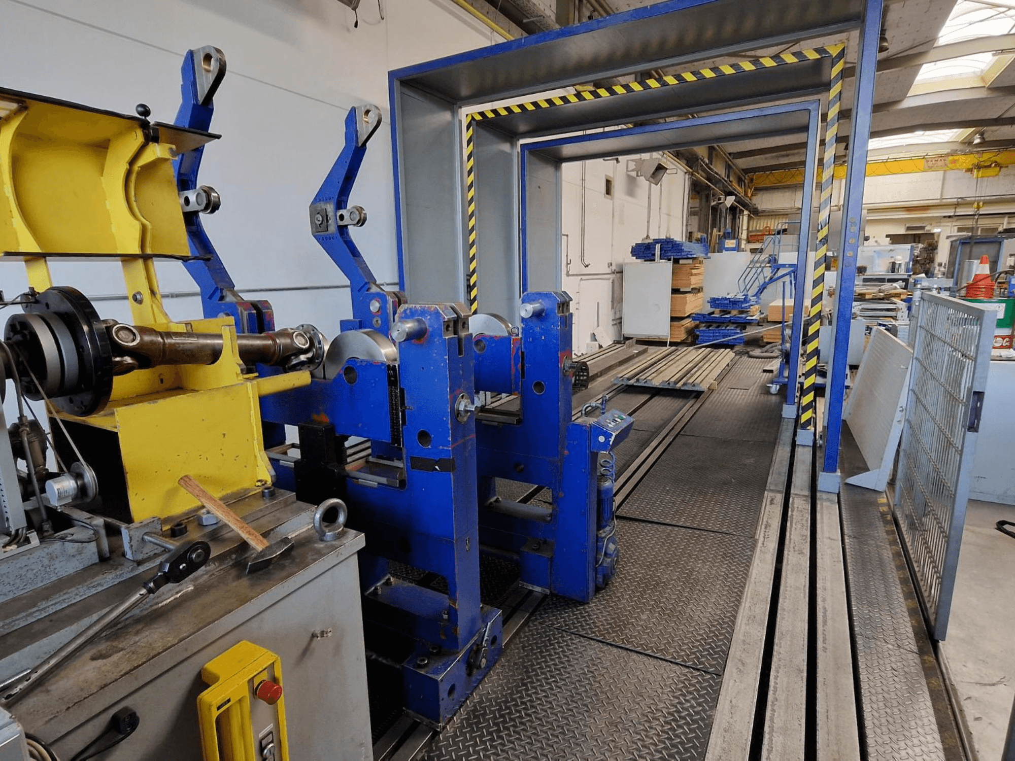 SCHENCK HM 70U BU machine tool, side view showing blue structure with yellow components and control panel in industrial setting.