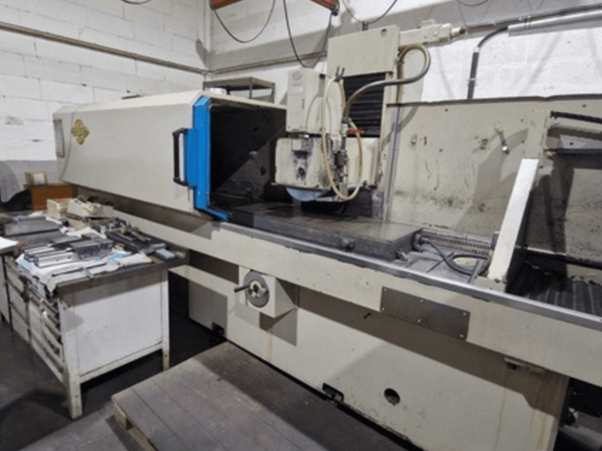 ELB Surface Grinder in a workshop setting; side view showing the grinding table and controls, with tools nearby.