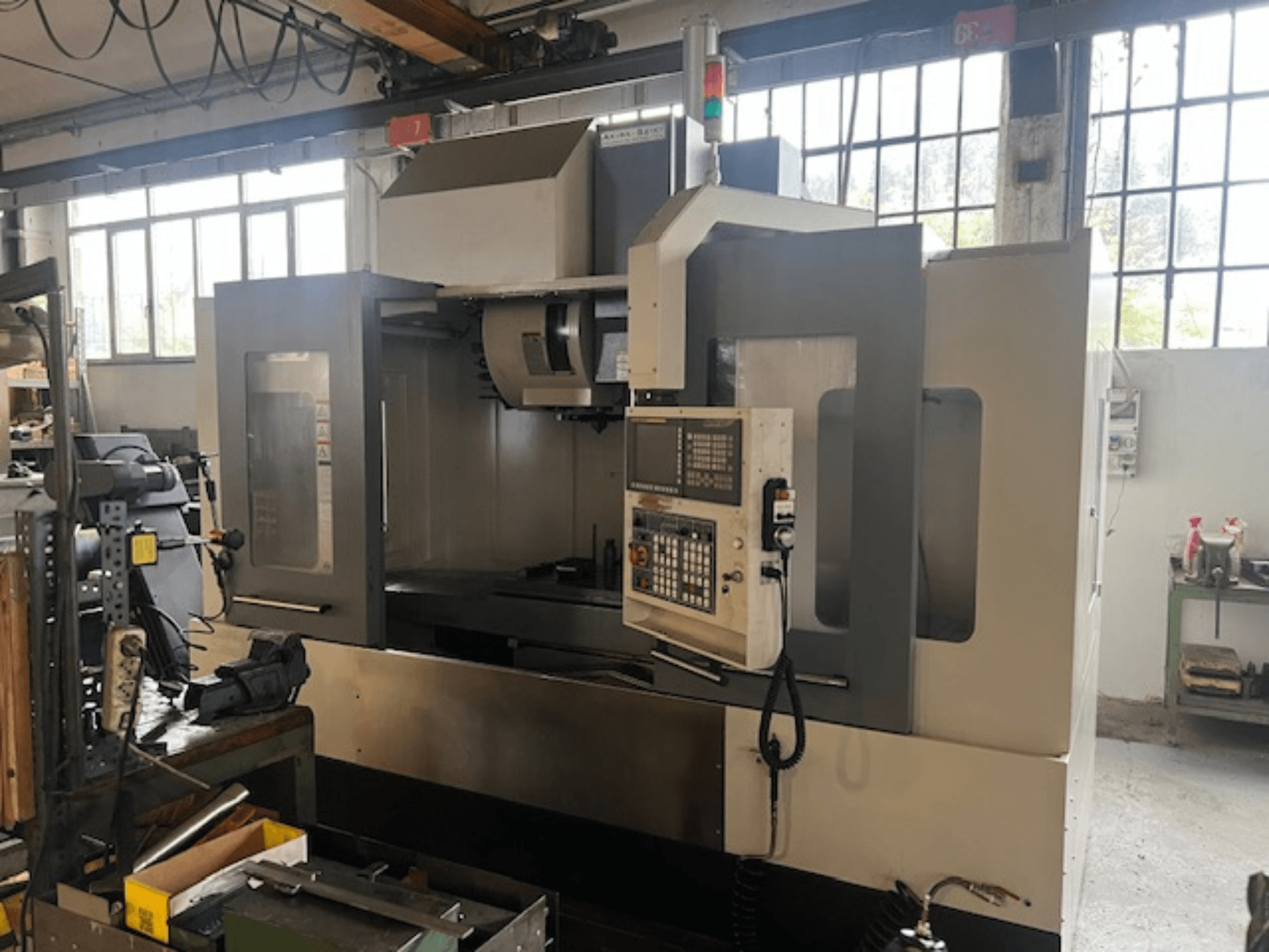 High-tech CNC milling machine, front view, with digital controls, basic safety indicators, and a compact design.