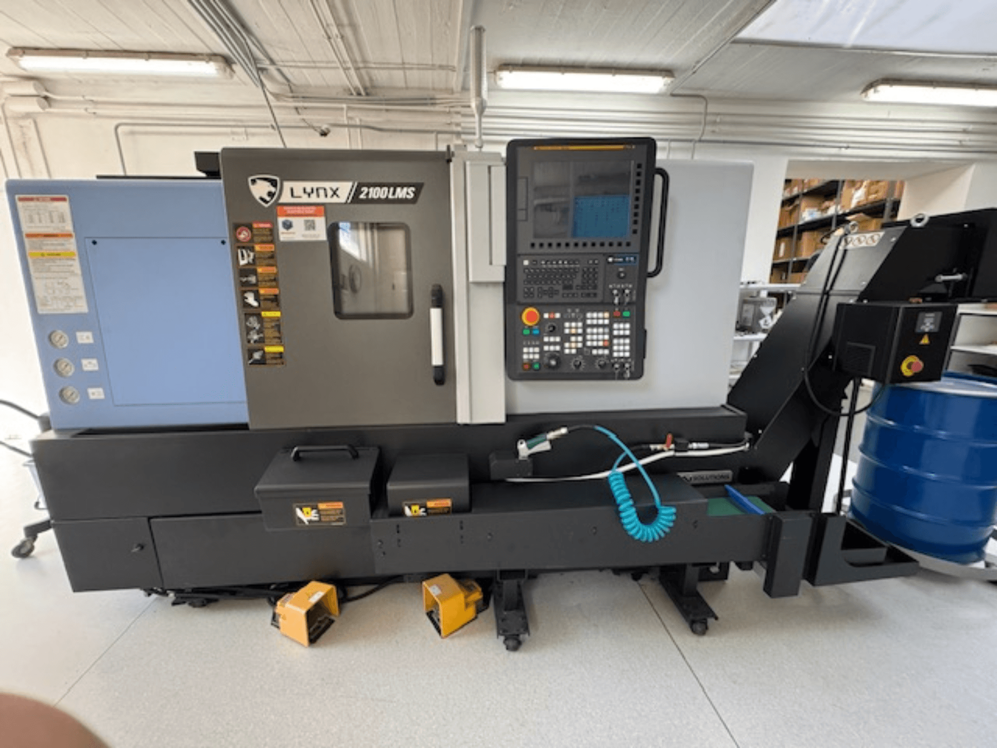 DOOSAN LYNX 2100LMSA horizontal turning machine, front view, features control panel, coolant hose, and storage boxes.