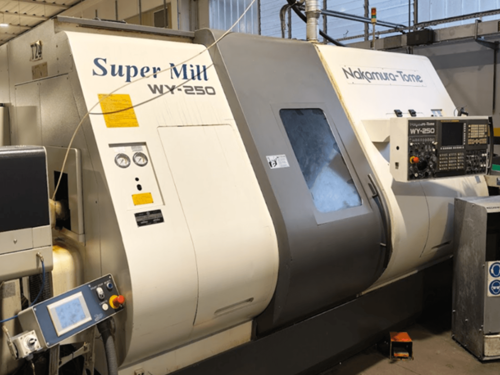 Horizontal turning machine NAKAMURA-TOME WY 250 in front view; features control panel and display, labeled "Super Mill."