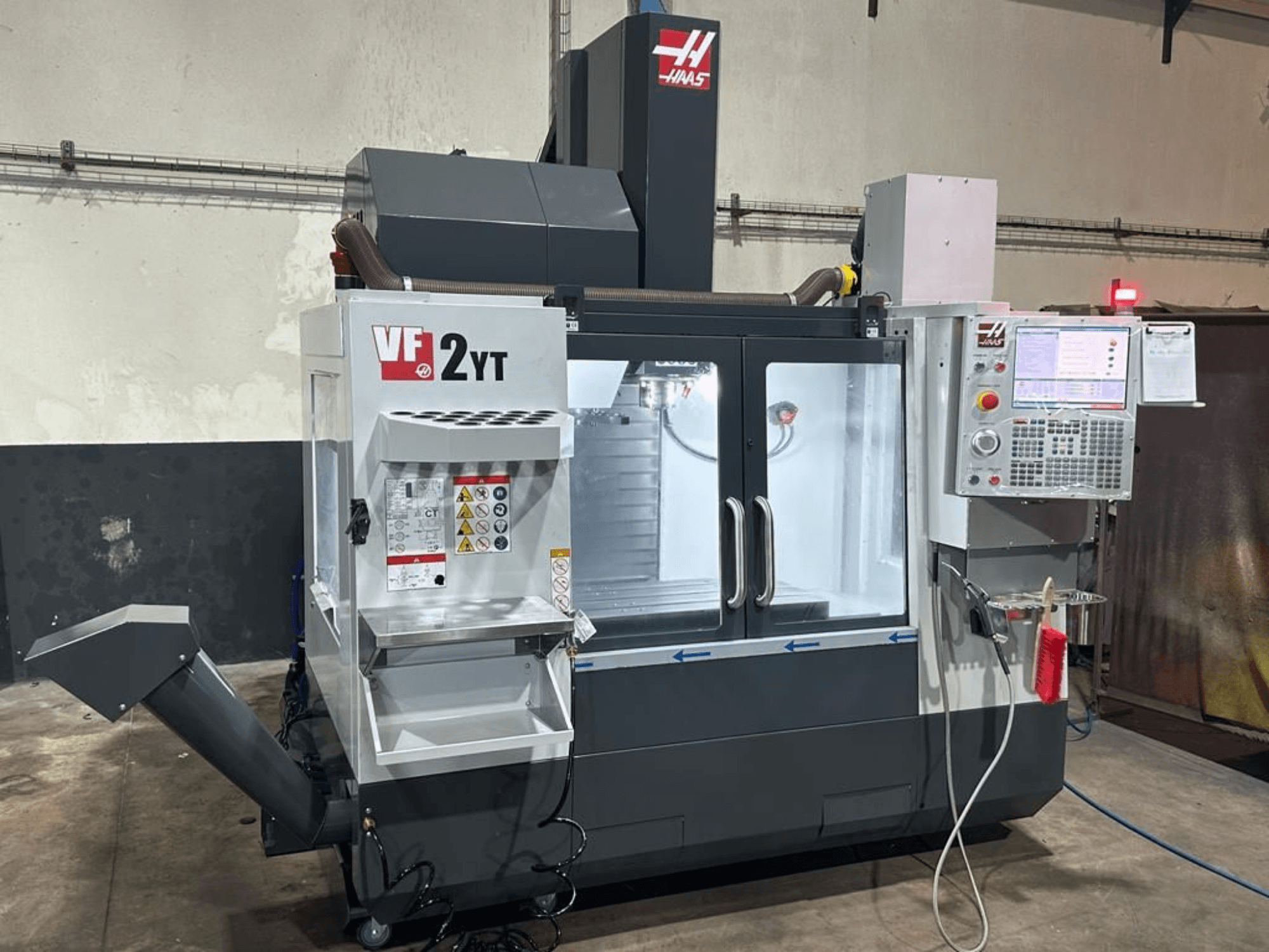 HAAS VF-2YT-EU vertical machining center in front view, showcasing control panel and tool storage compartment.