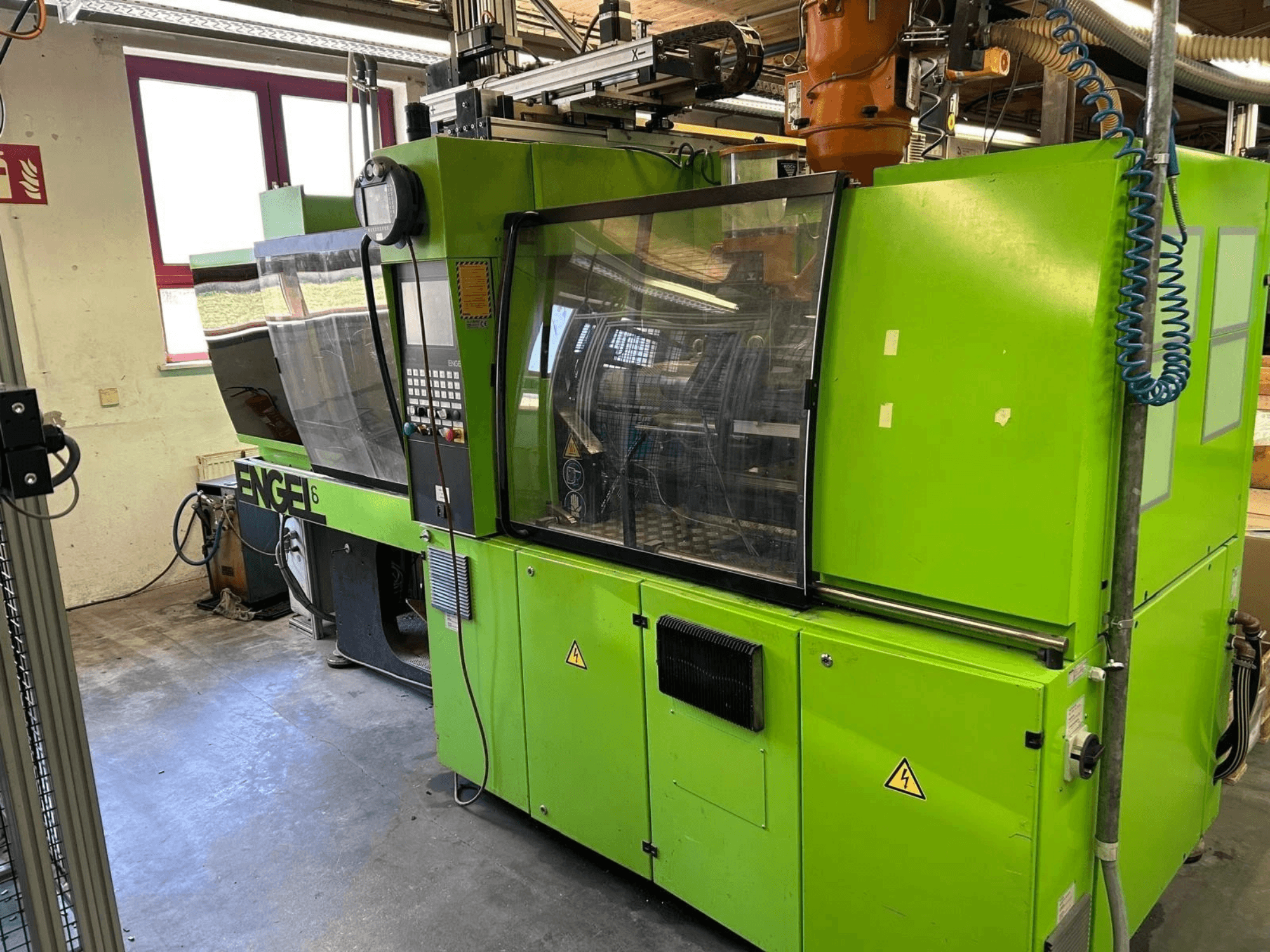 Front view of Engel VICTORY 330/80 Tech hydraulic injection moulding machine, showcasing green exterior and control panel.