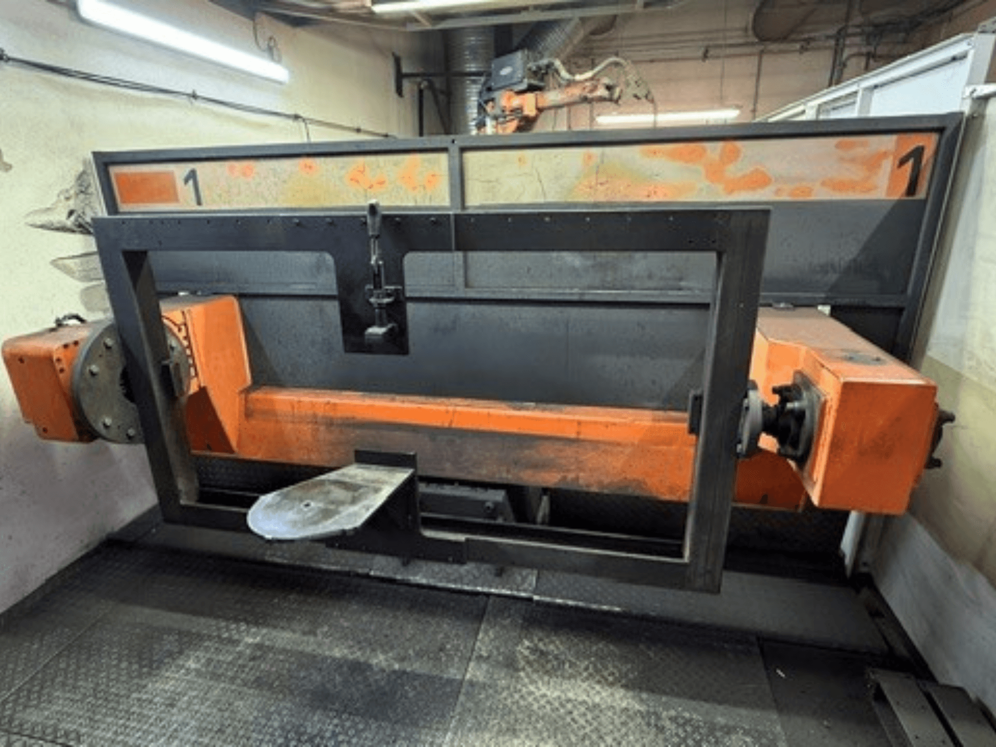 Front view of ABB IRB 2400L Welding Cell showing a large robotic frame with orange and black components in a workshop setting.