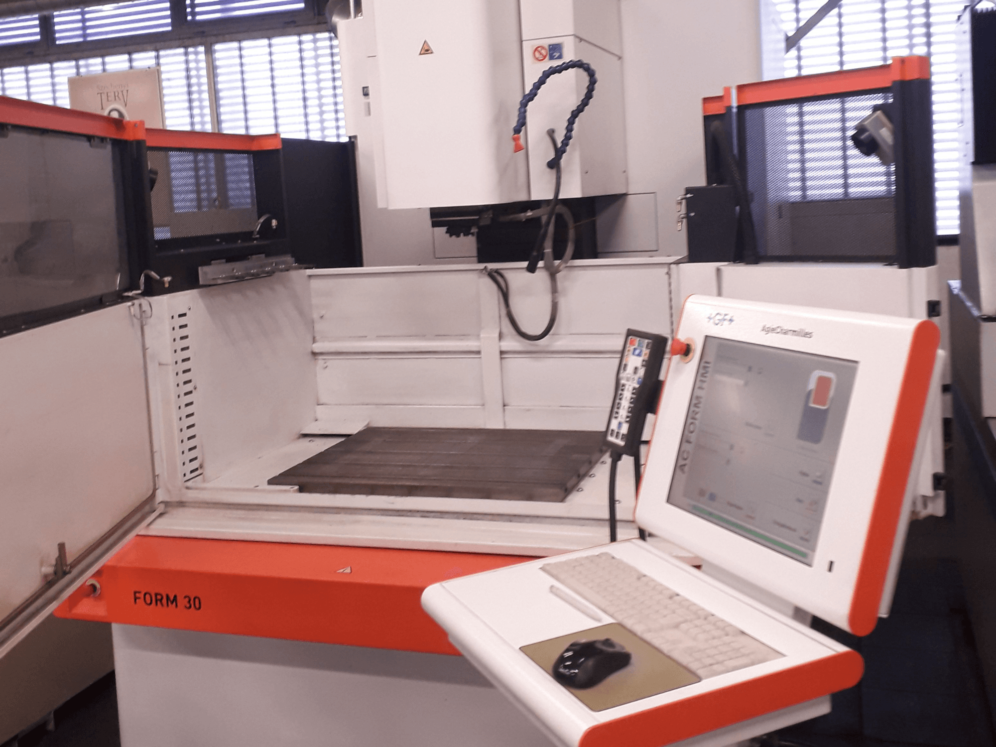 AgieCharmilles FORM 30 die-sinking EDM machine shown from a front view with a control panel and work area inside.