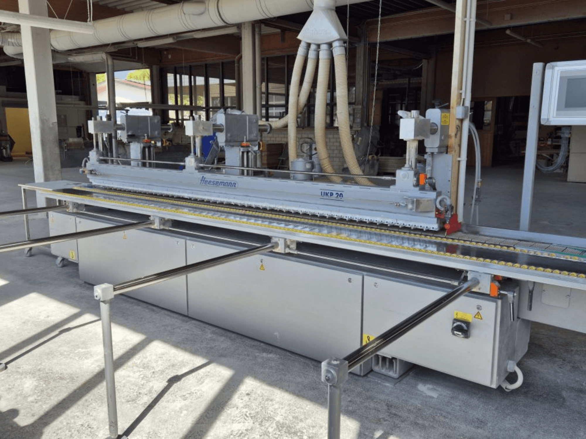 HEESEMANN UKP 20 belt sander shown in front view, featuring dual motors, adjustable conveyor, and protective covers.
