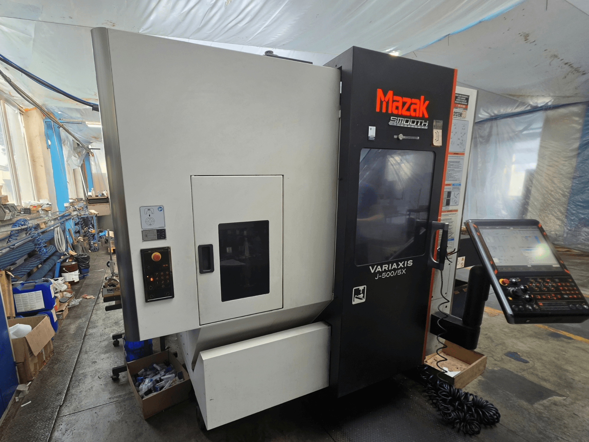 Mazak VARIAXIS J-500/5X vertical machining center, side view showing controls and display, set in a workshop environment.