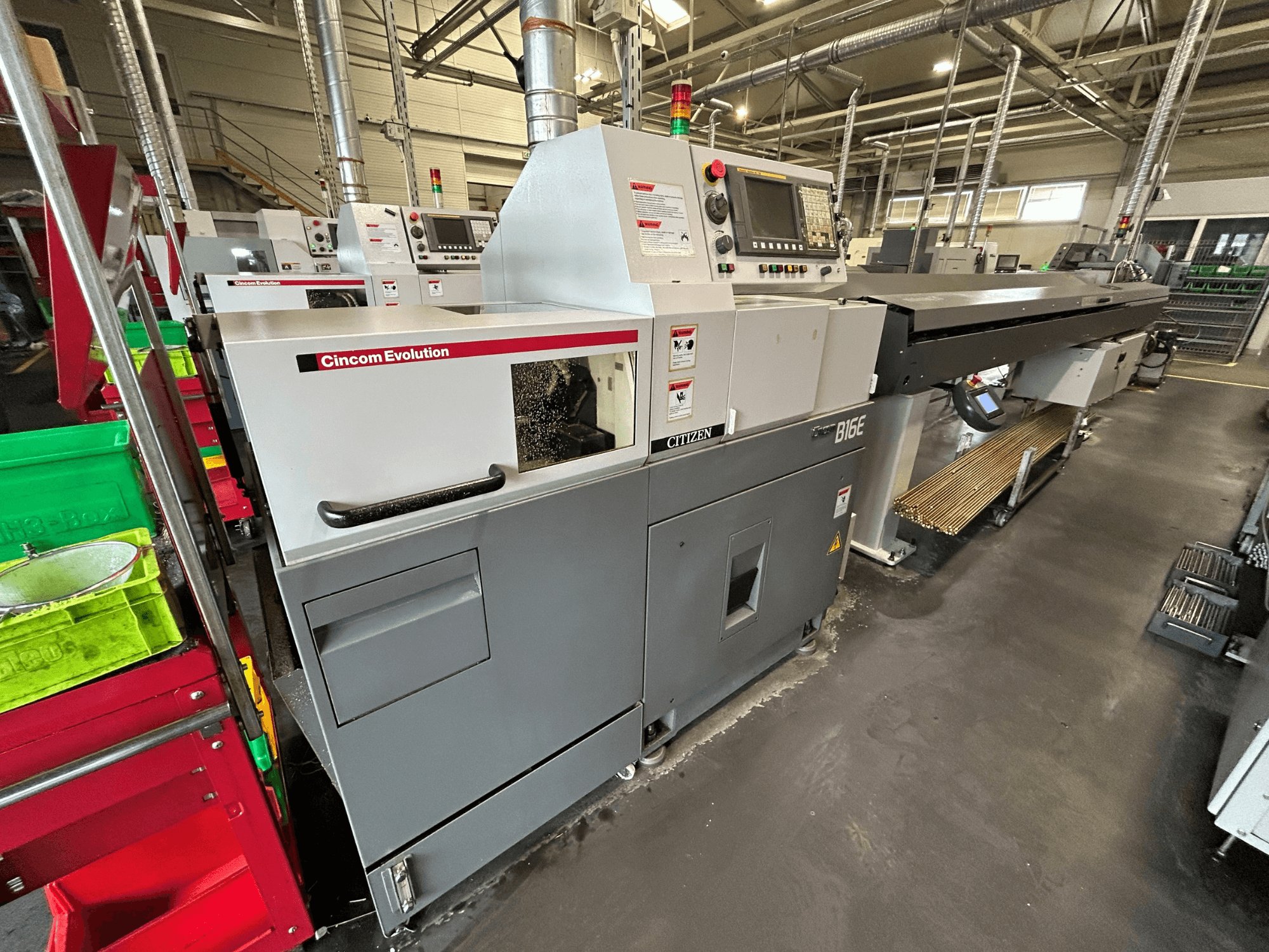Citizen B16 horizontal turning machine in a side view, featuring control panel, work area, and nearby material bins.