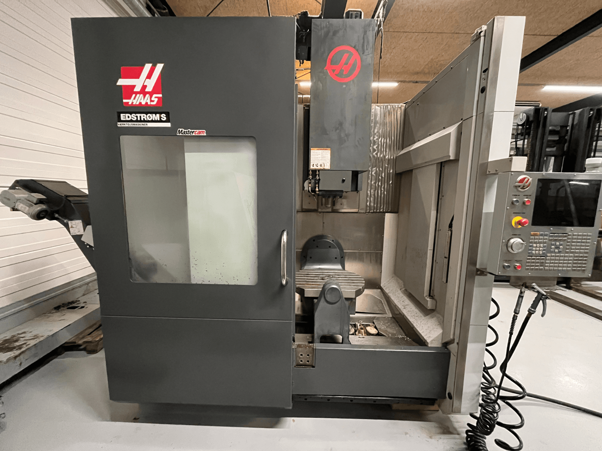 Haas EDSTROM S CNC machine front view showcasing control panel, spindle head, and machining table.