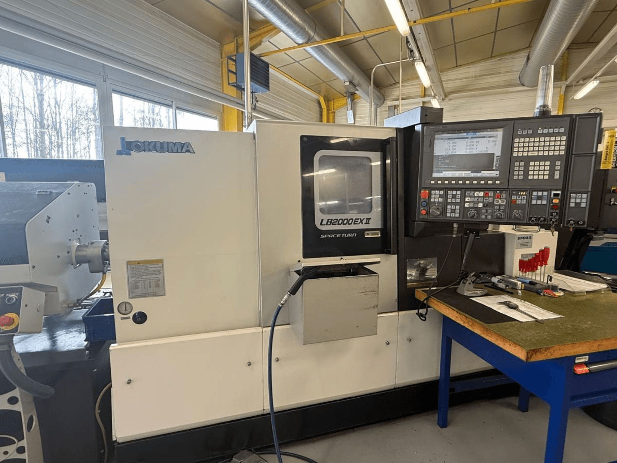 Okuma LB2000EX II horizontal turning machine, front view; features control panel, spindle area, and surrounding workspace.
