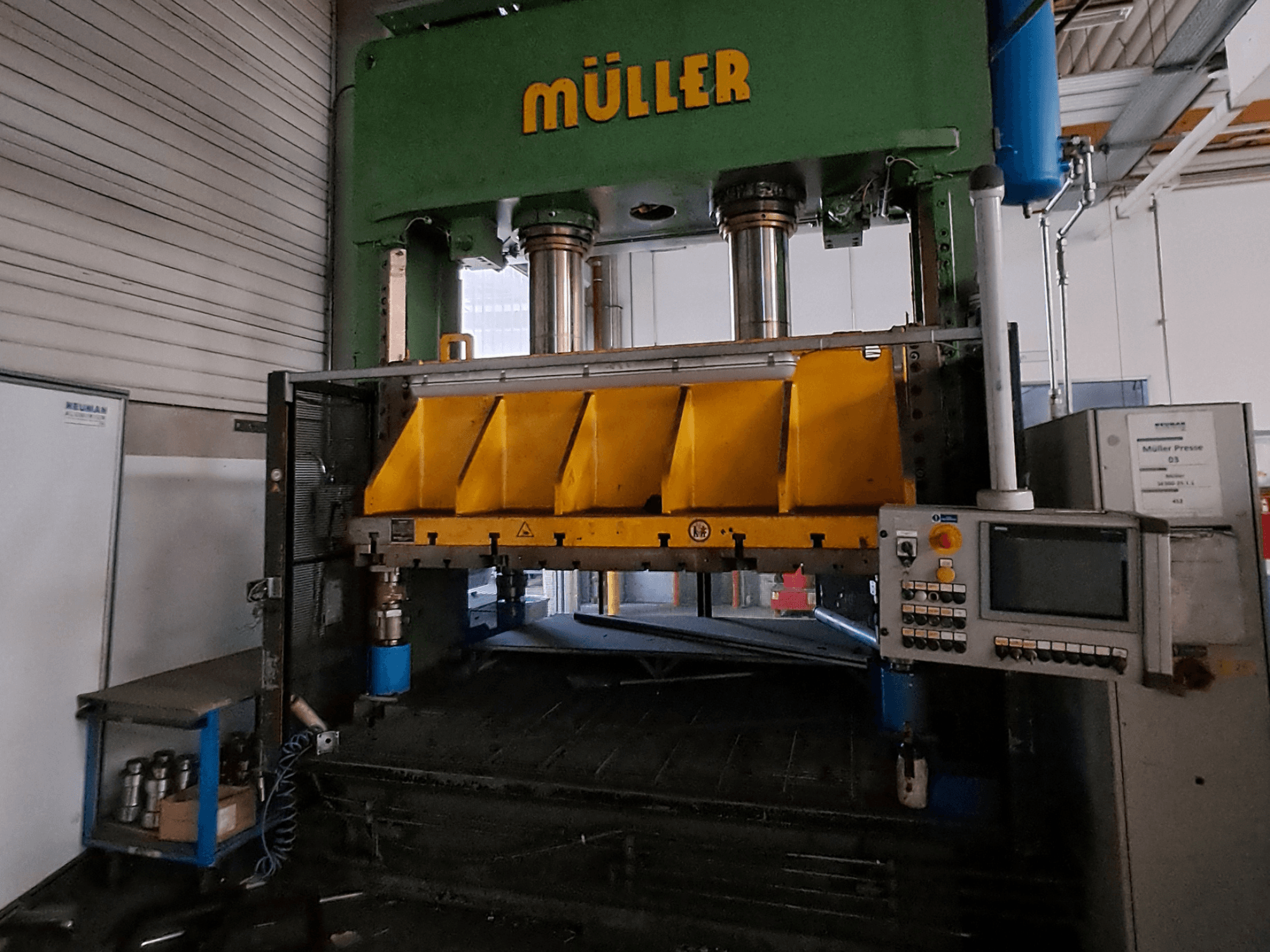Front view of a Müller SE 300-25.1.1 metal press, featuring yellow pressing components and a control panel on the side.