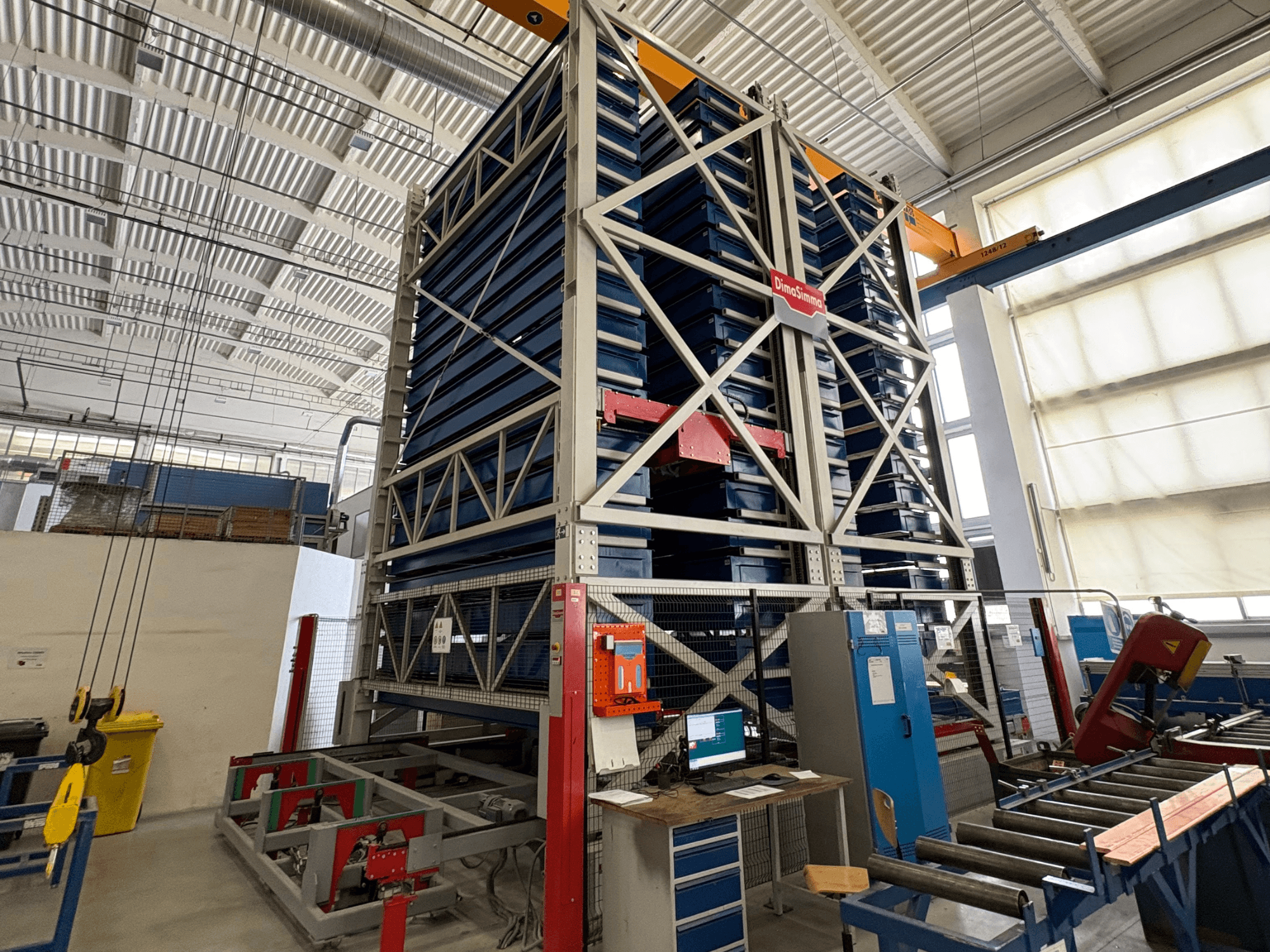 DimaSimma EMS-30 TWIN sheet metal machine in a workshop, front view with stacked blue trays and control station visible.