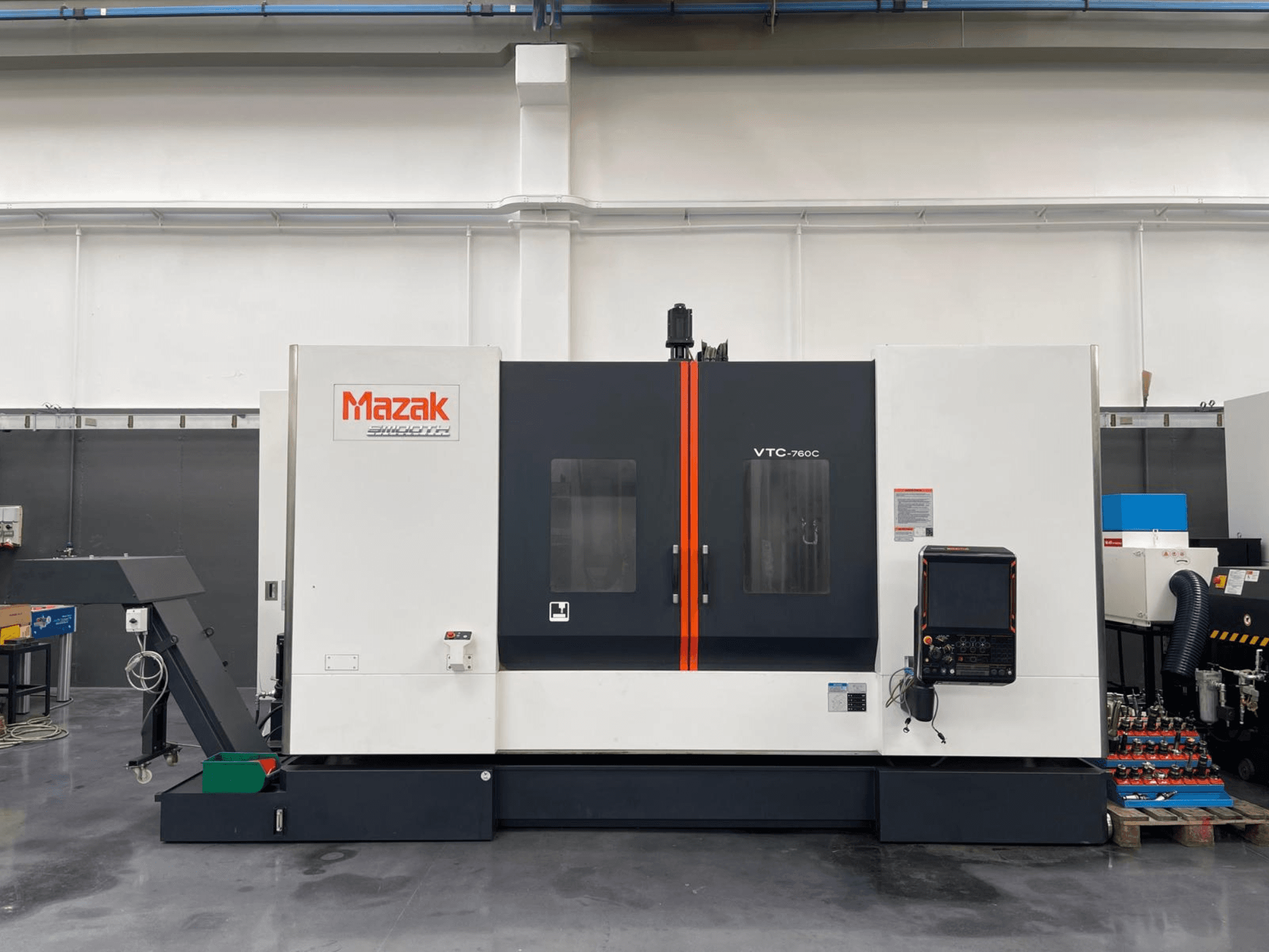 Mazak VTC 760C Vertical Machining Centre, side view showcasing controls, white and black exterior, and orange accents.