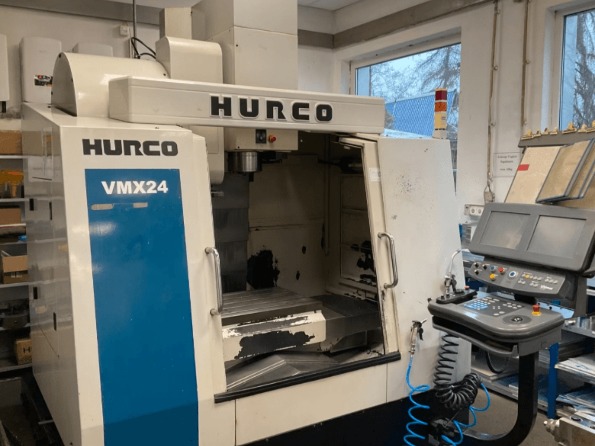 Hurco VMX24 Vertical Machining Centre in front view, showing control panel, spindle head, and work area, with some wear visible.
