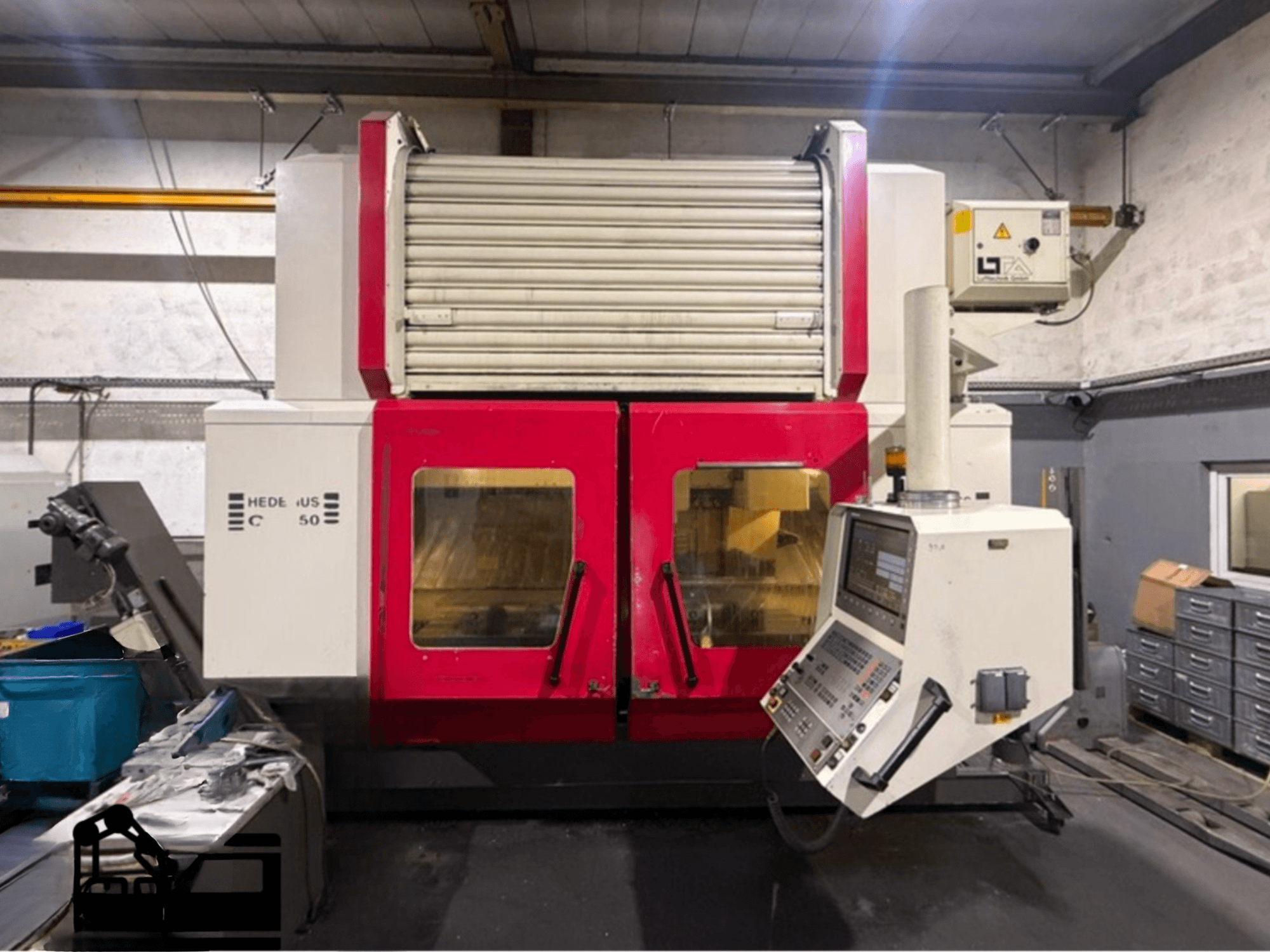 Vertical Machining Centre HEDELIUS BC 50 in red and white with control panel, side view, showcasing operational features.