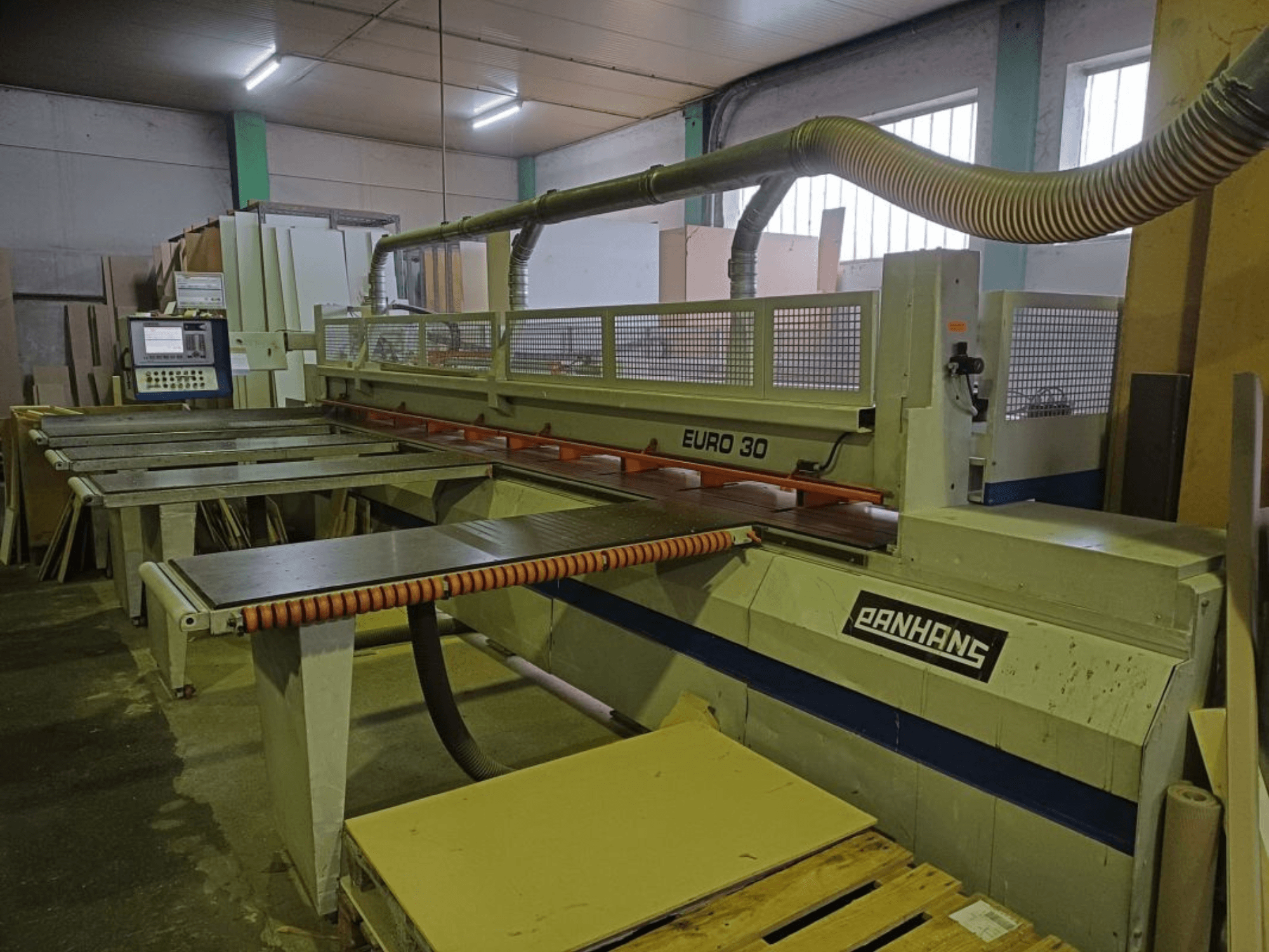 Front view of PANHANS EURO 30 panel saw with control panel, cutting table, and dust extraction hose in a workshop setting.