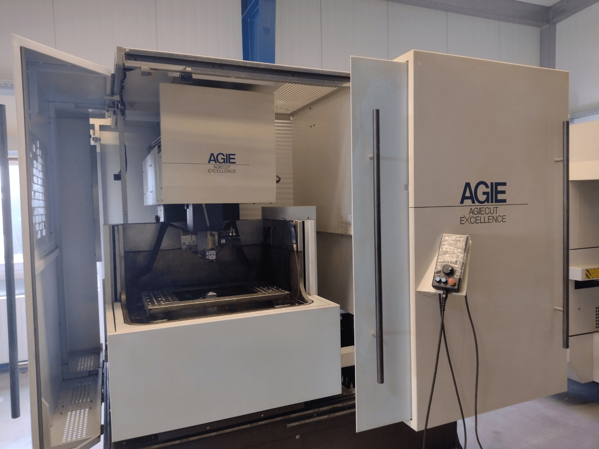 AGIE Progress 3 Wire EDM machine in front view, featuring an open cabinet, control panel, and cutting area.