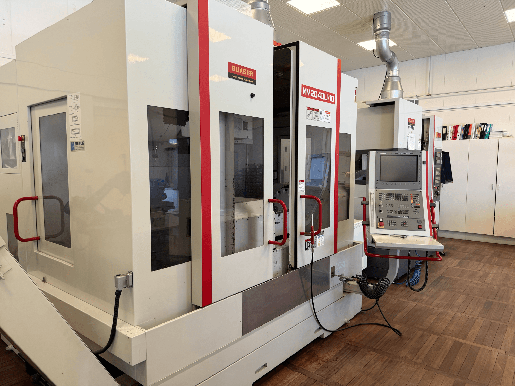 Front view of a Quaser MV204U/10 Universal Machining Centre, showcasing control panel and dual machine setup.