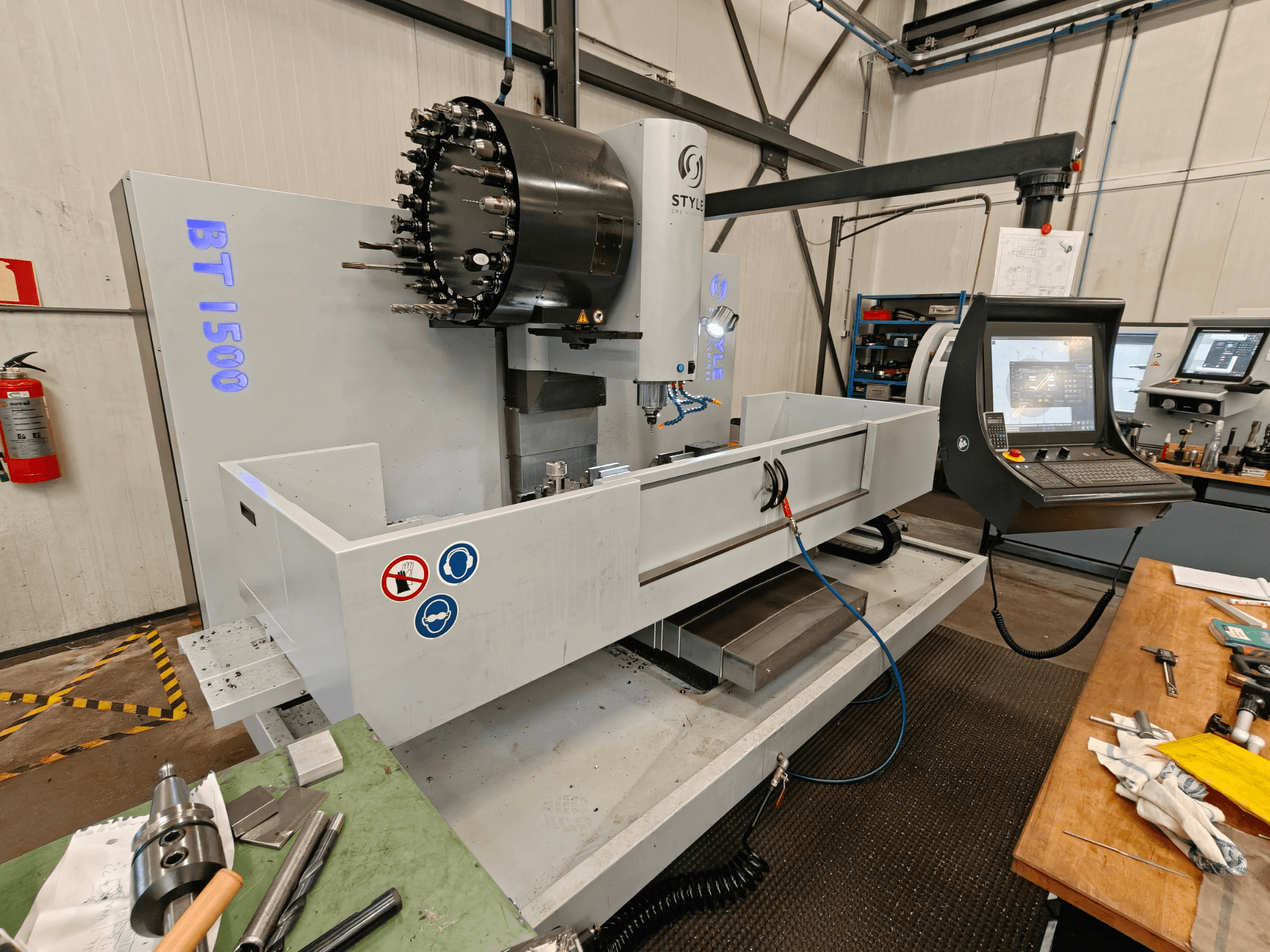 Vertical Machining Centre STYLE BT 1500 in a workshop, showcasing a control panel, tool holder, and work area.