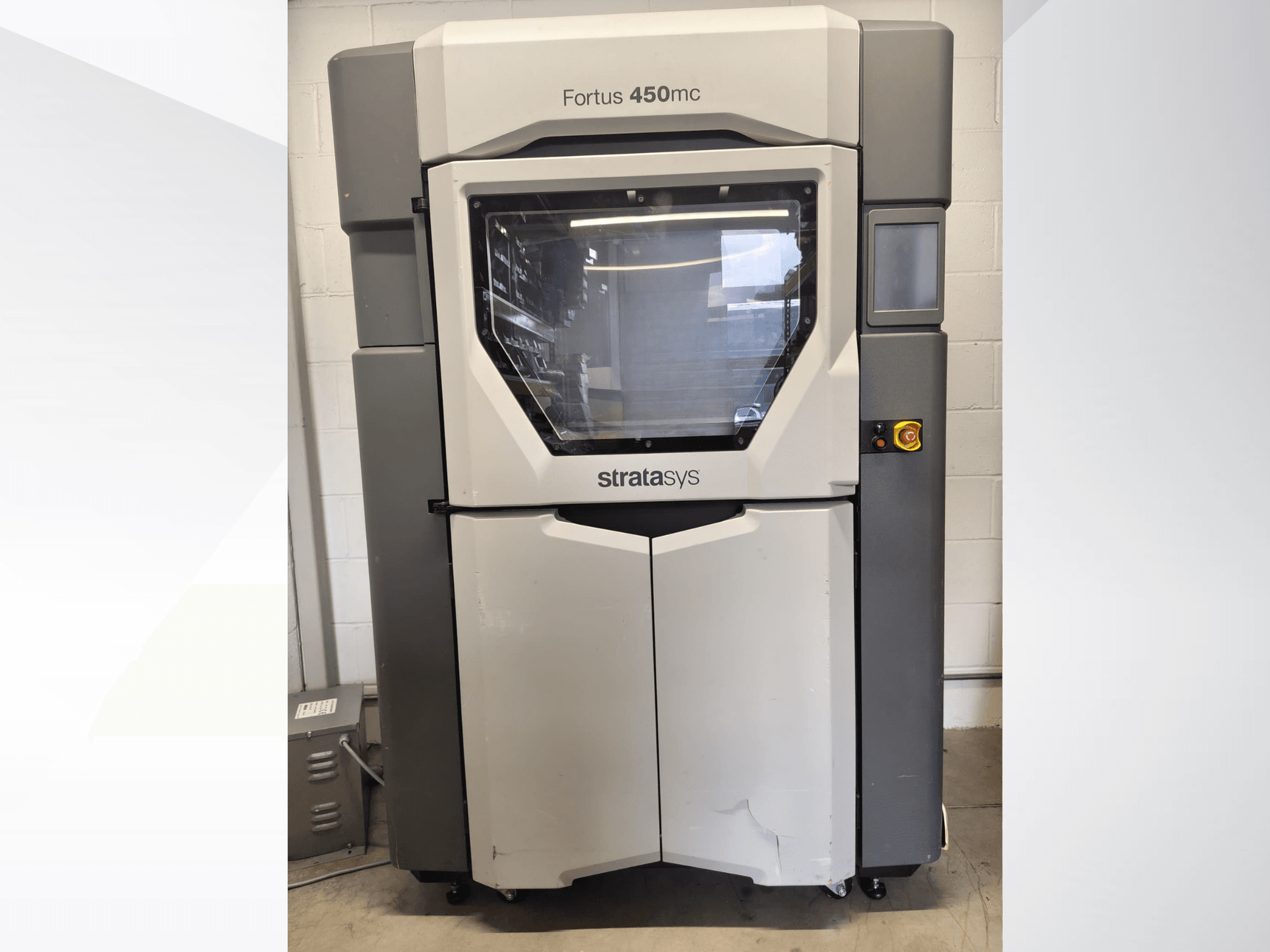 Stratasys Fortus 450mc plastic processing machine, front view, featuring a large window, control panel, and industrial design.