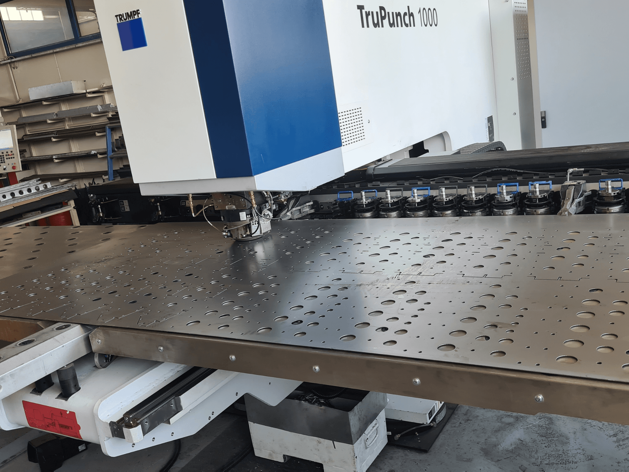 CNC punching machine TRUMPF TruPunch 1000, front view, showcasing a perforated metal sheet and tool setup.