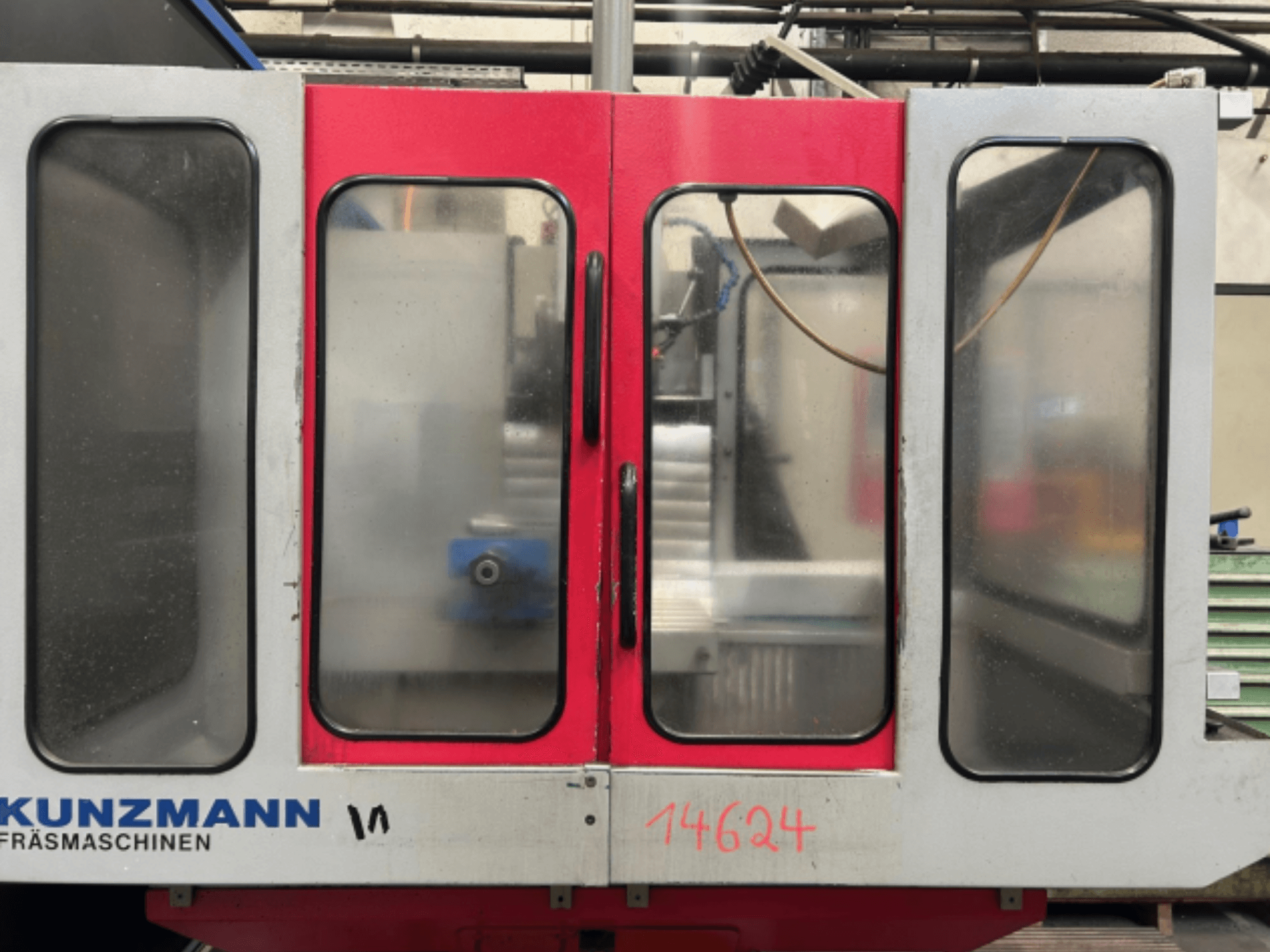 KUNZMANN CNC machine front view, featuring red and gray panels, with a visible control panel and tool holder inside.