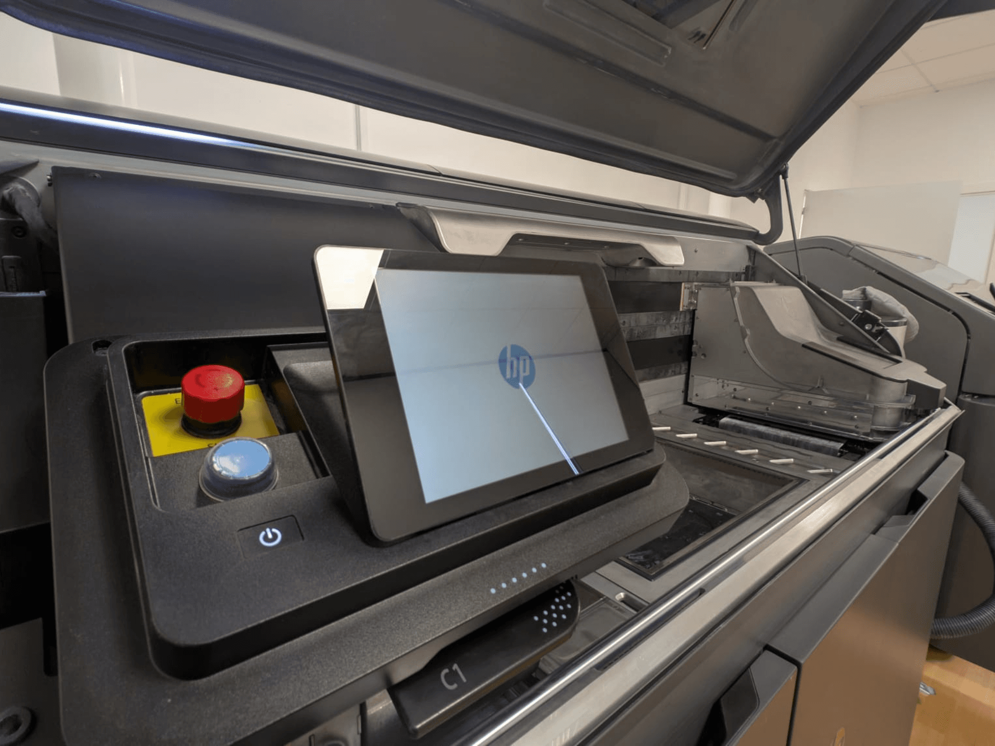 HP printer control panel showing a tablet display, red and blue buttons, and a side view of the printer's interior components.