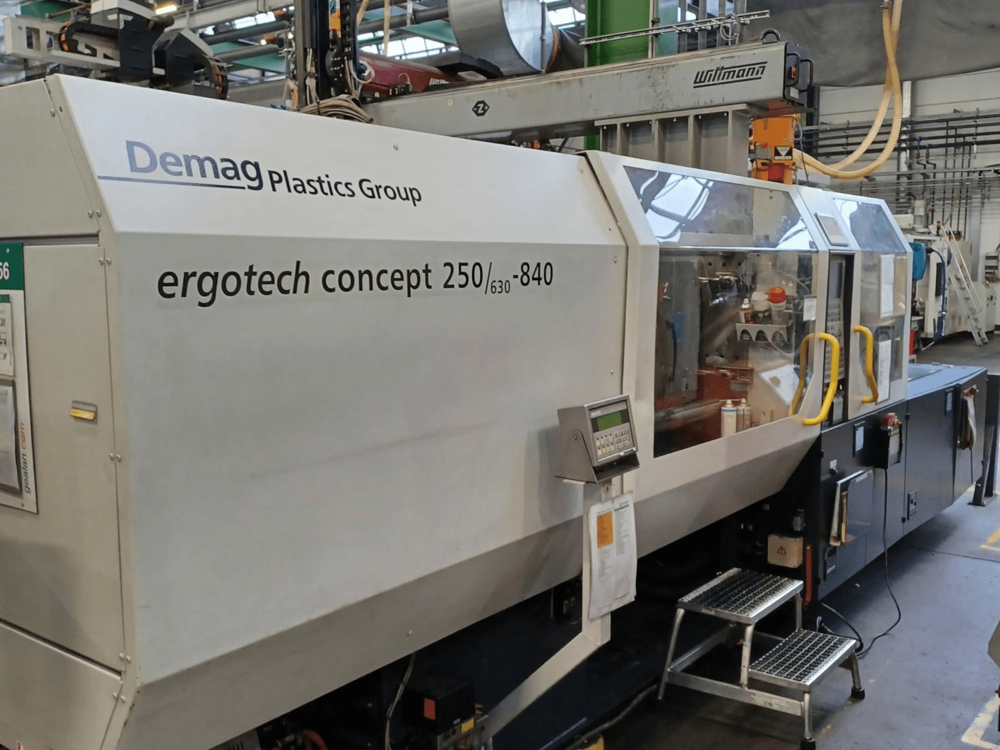 Demag ergotech concept 250/630-840 injection molding machine, front view, showing digital controls and clear safety covers.