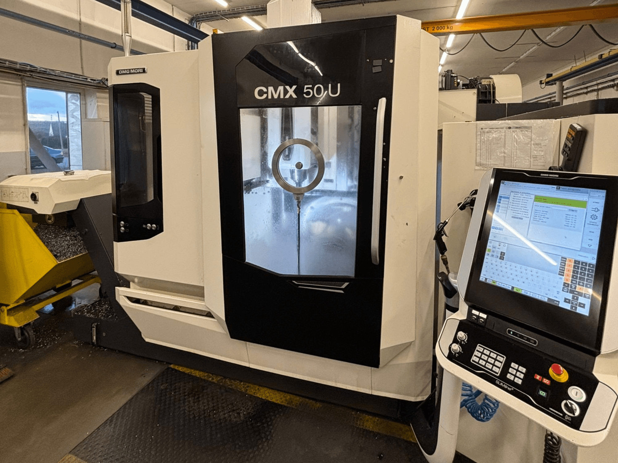 DMG MORI CMX 50 U vertical machining centre, front view with control panel and glass display, showcasing internal mechanics.