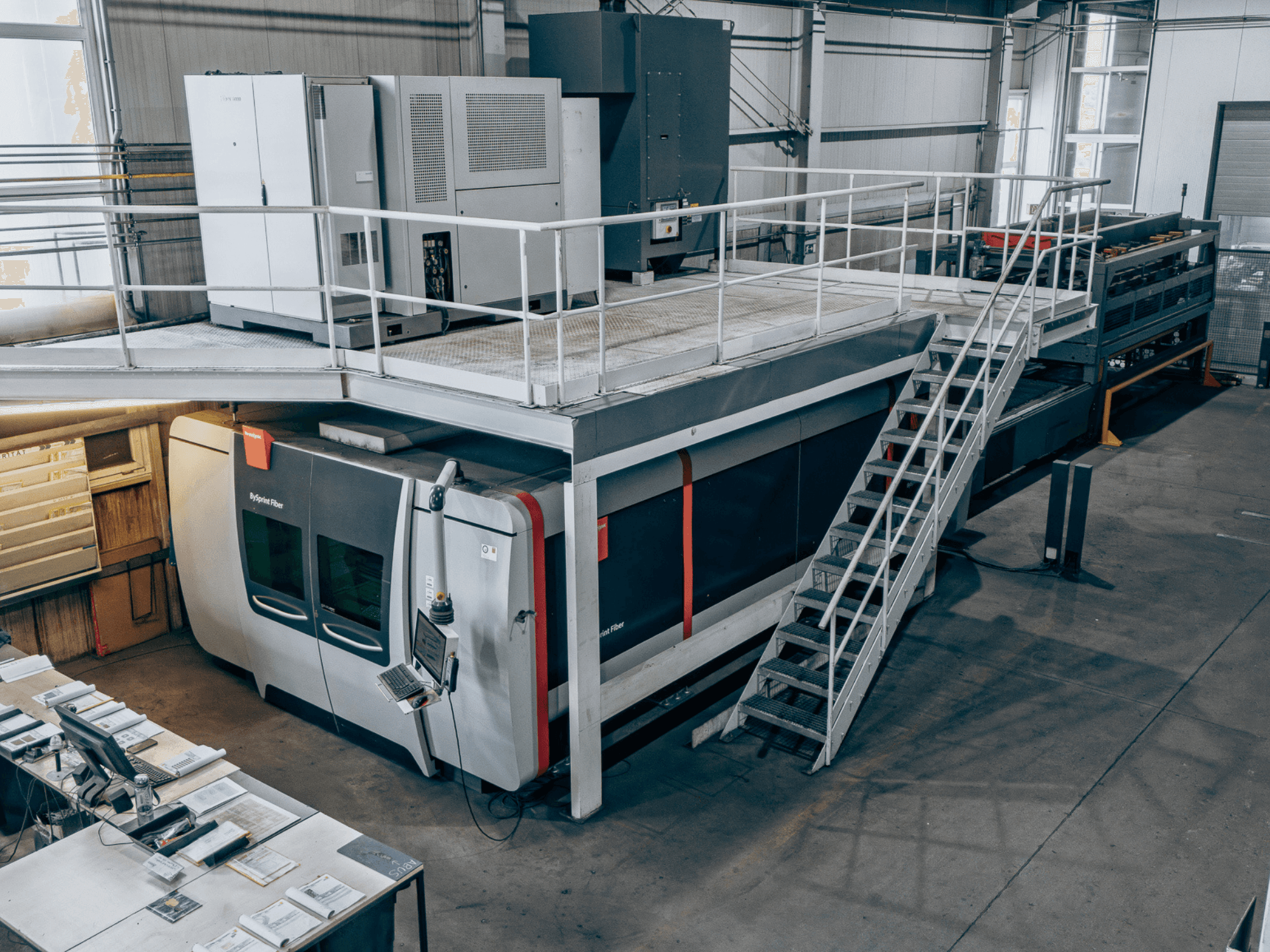 Bystronic BySprint Fiber 4020 fiber laser cutting machine with ByTransExtended 4020, viewed from above, showing control panel and stairs.