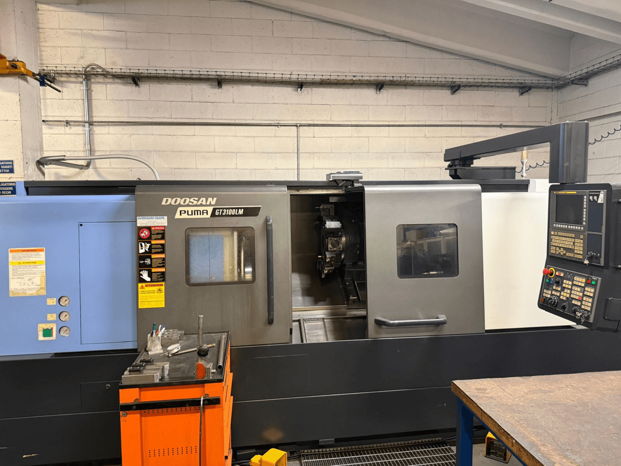 Front view of DOOSAN PUMA GT3100LM horizontal turning machine, showcasing control panel and work area with tools.
