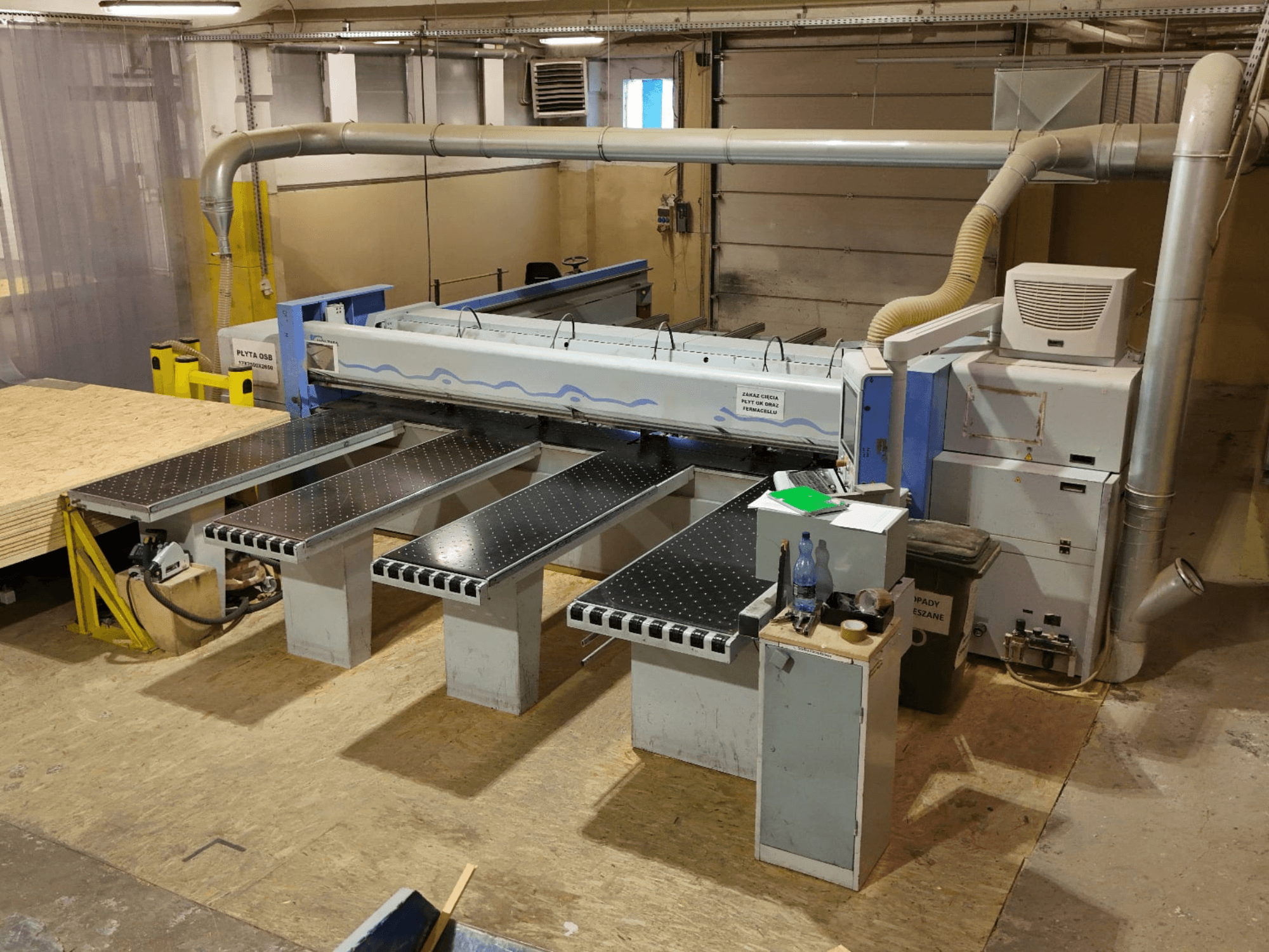 HOLZMA HPP 350/43/38 panel saw in a workshop, viewed from above, showing cutting area and support tables.