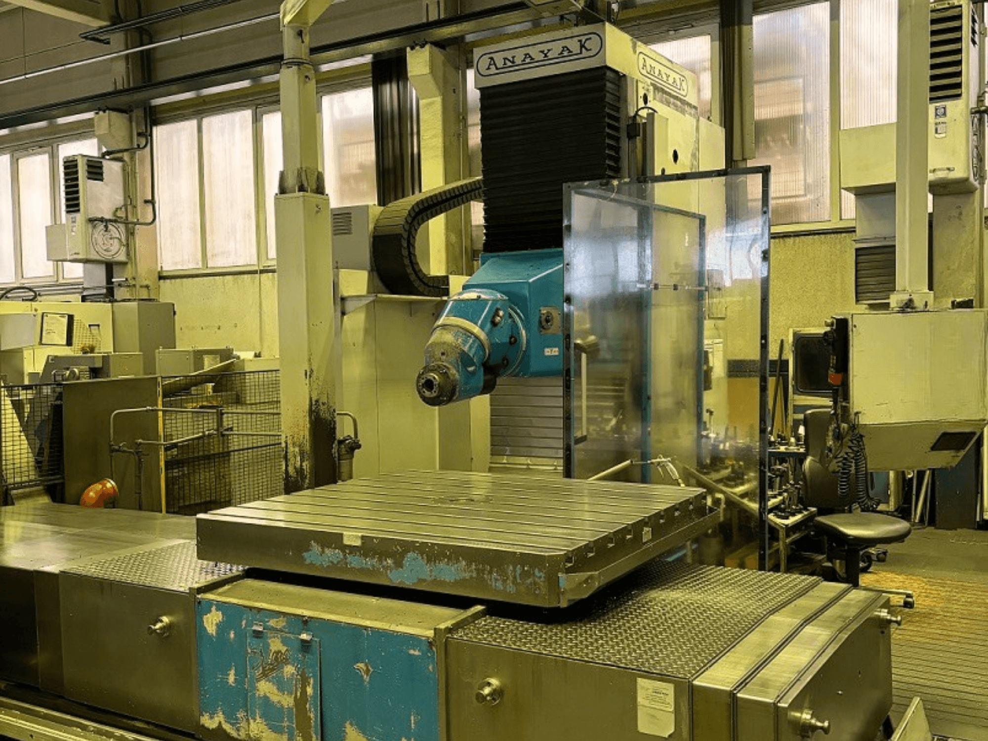 ANAYAK VH plus-2000 bed type milling machine, front view, featuring a large flat worktable and blue control panel.