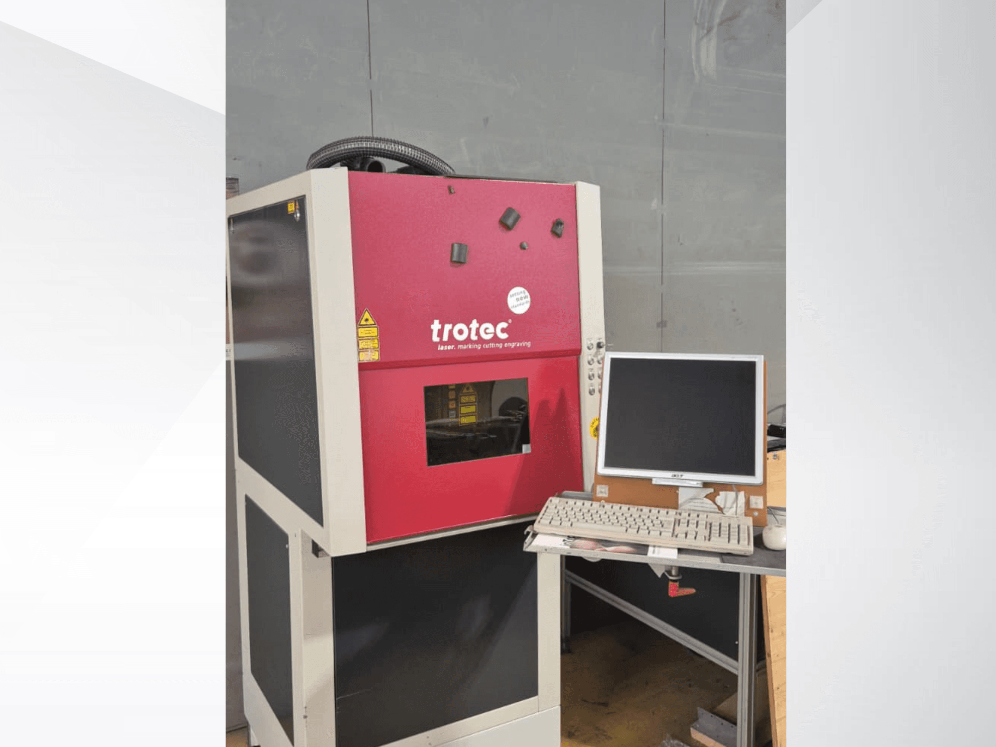 Red Trotec Laser-Work-Station viewed from the front, featuring a monitor and keyboard on a workstation.
