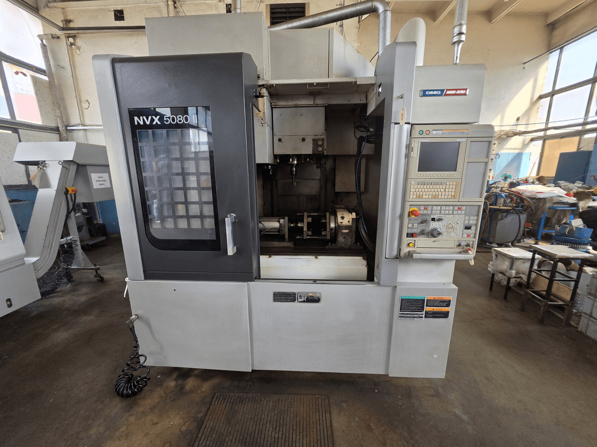 Front view of DMG Mori Seiki NVX 5080 II/40 vertical machining center with control panel and clear window, showcasing machining area.
