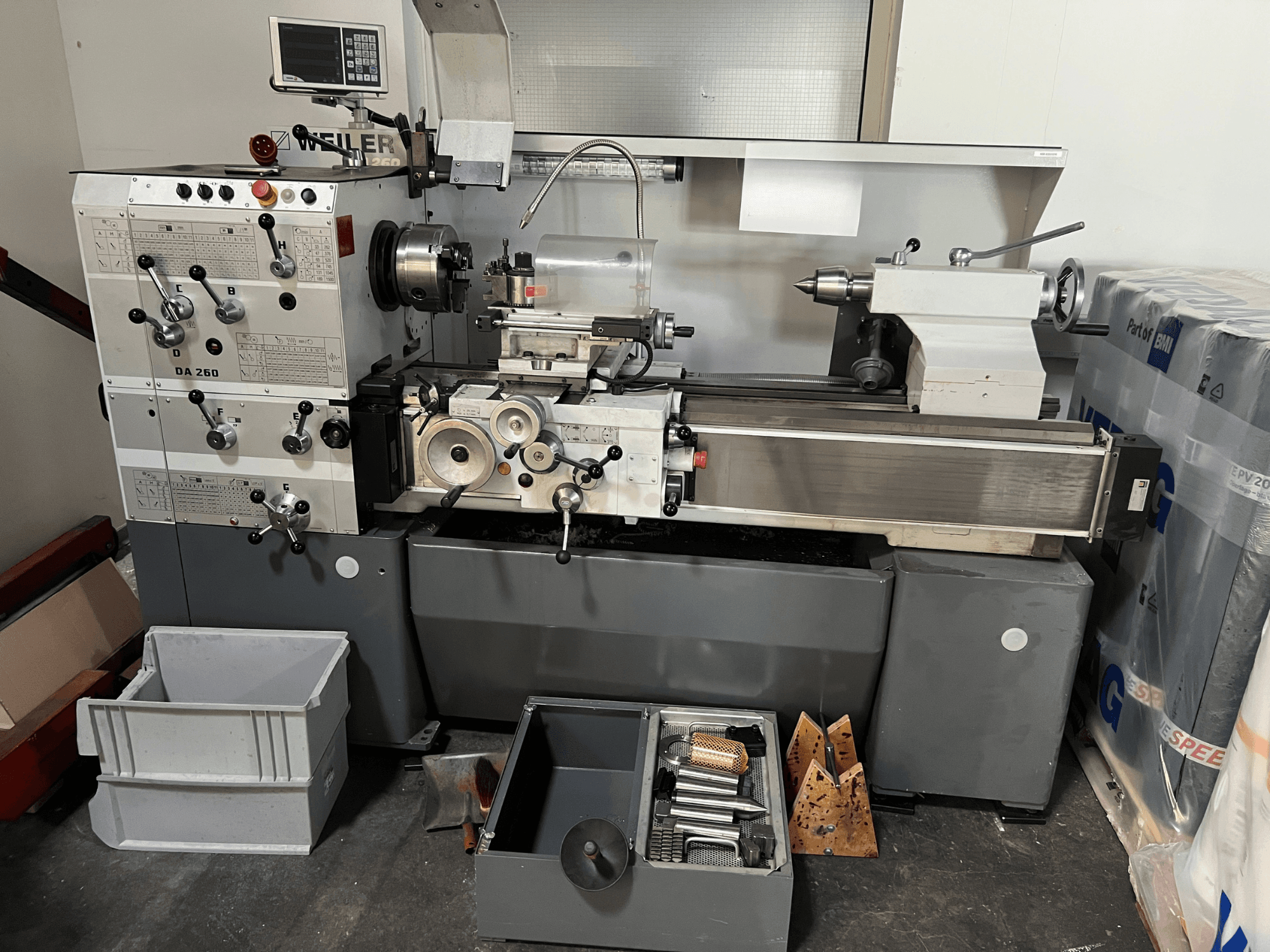 Weiler DA 260 X 1000 horizontal turning machine in front view, featuring control panel and tools, with storage bins below.