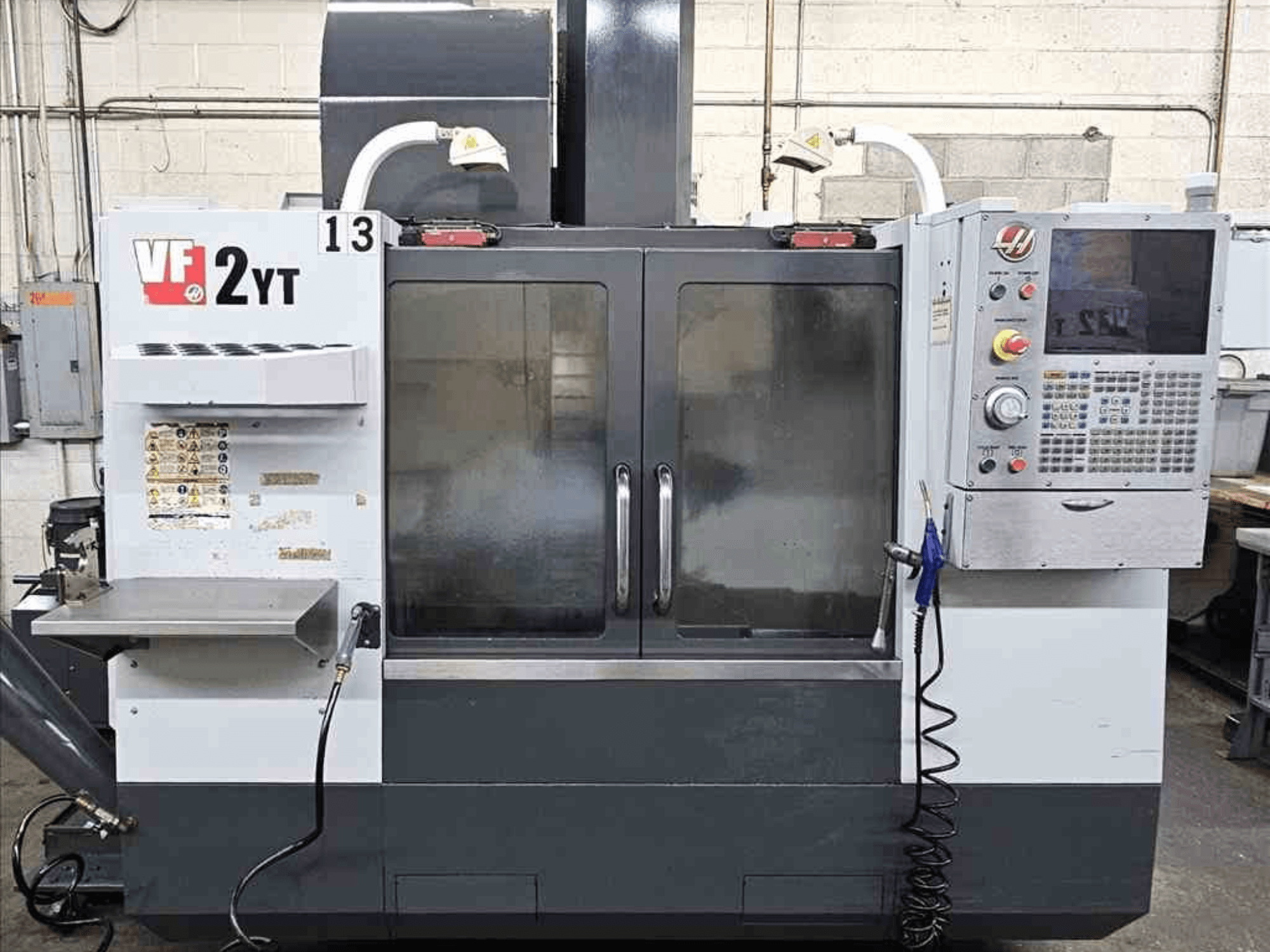 Front view of a HAAS VF-2YT Vertical Machining Centre, showcasing control panel and glass doors.