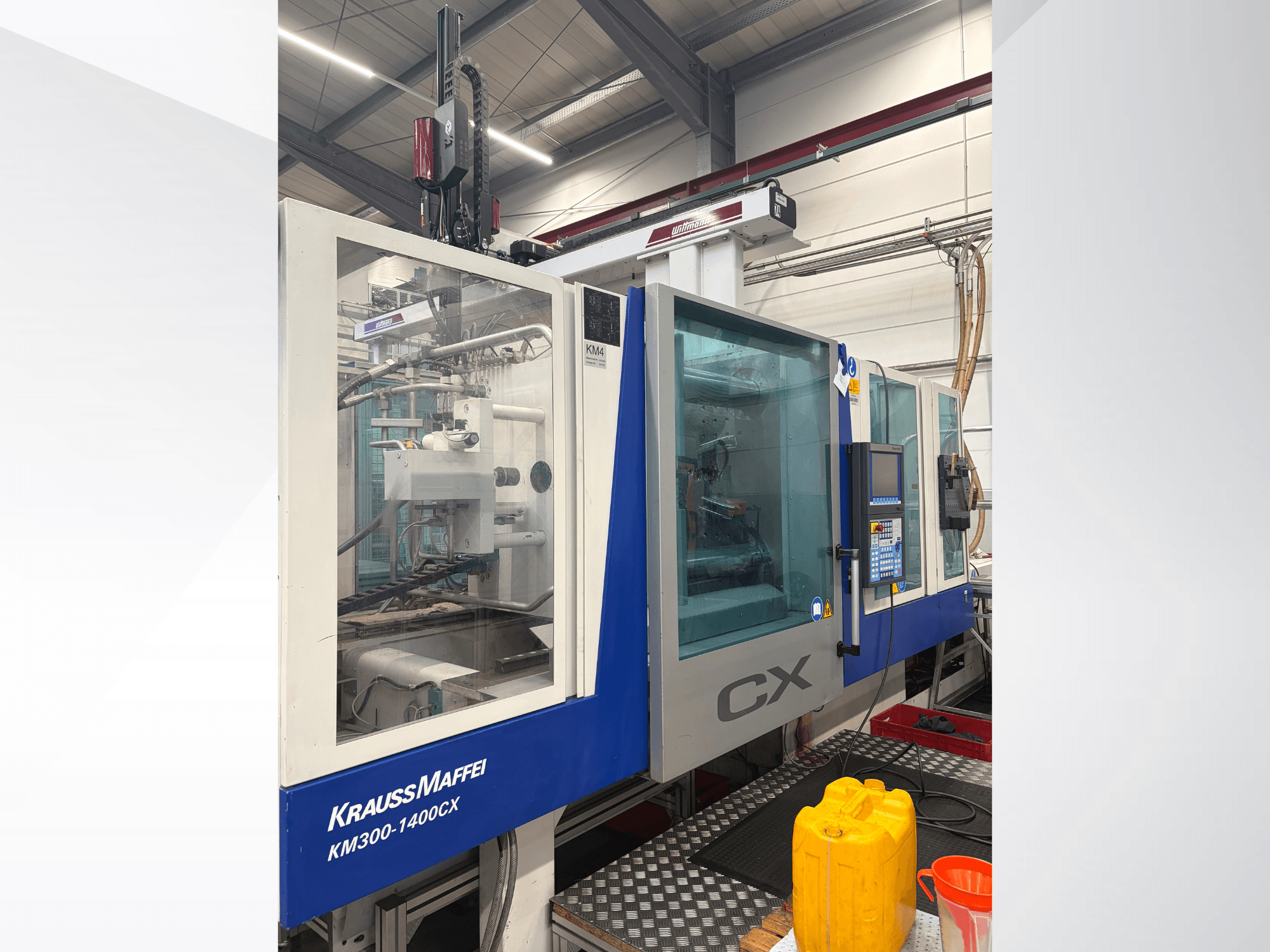 Krauss Maffei 300-1400 CX hydraulic injection molding machine, front view with control panel and transparent protective enclosure.
