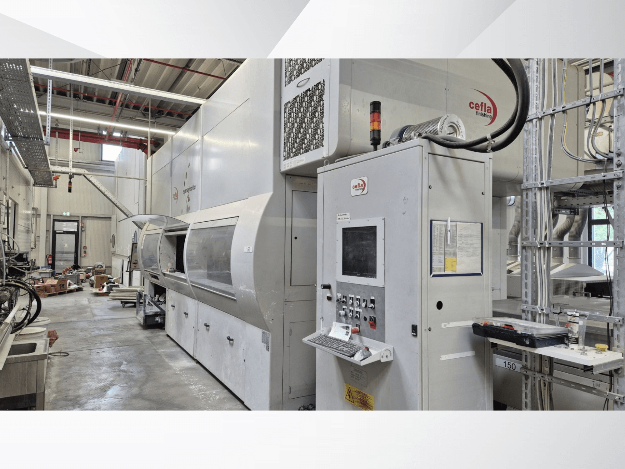 Cefla Spraybotic MD production line in a workshop, front view showing control panel and spray chamber with transparent cover.