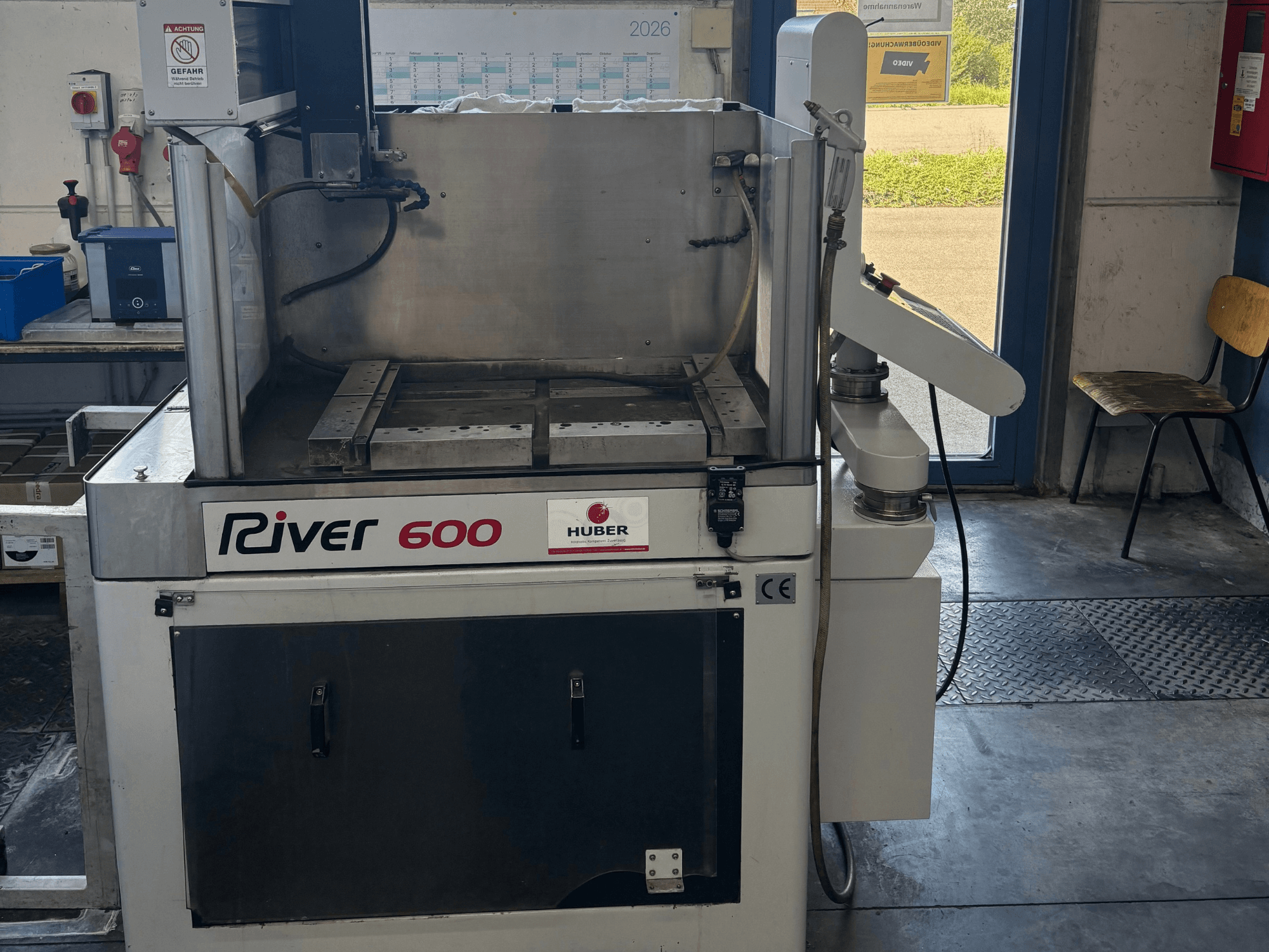 HUBER River 600 CNC die-sinking EDM machine, front view, featuring a partially open work chamber and control panel.