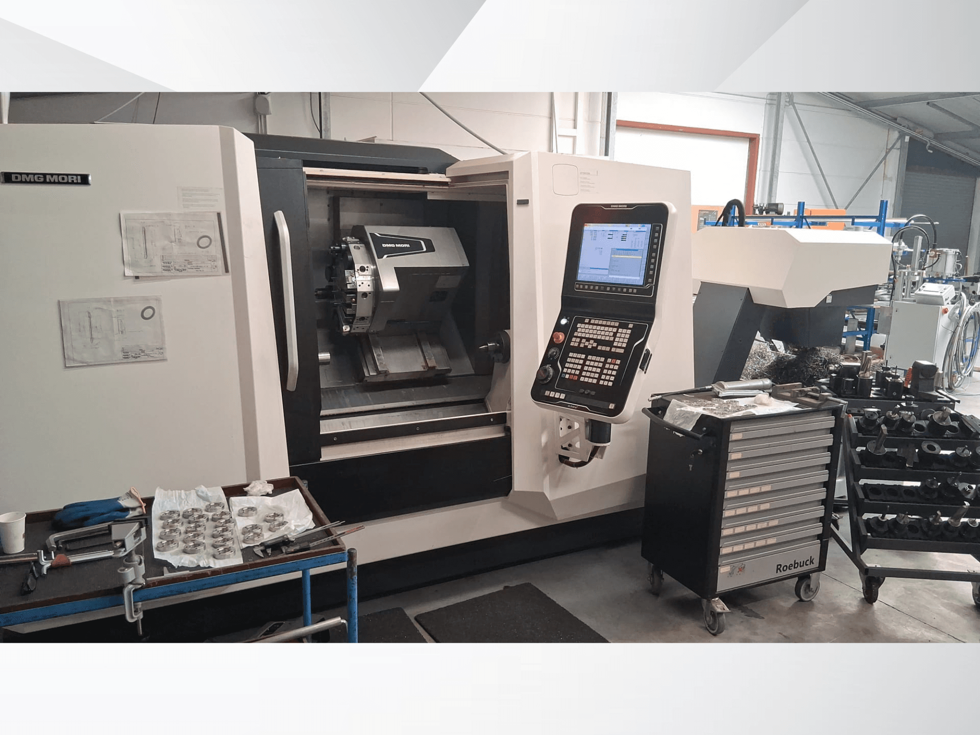 DMG MORI CLX450 horizontal turning machine from a front view, featuring control panel, work area, tools, and metal parts.
