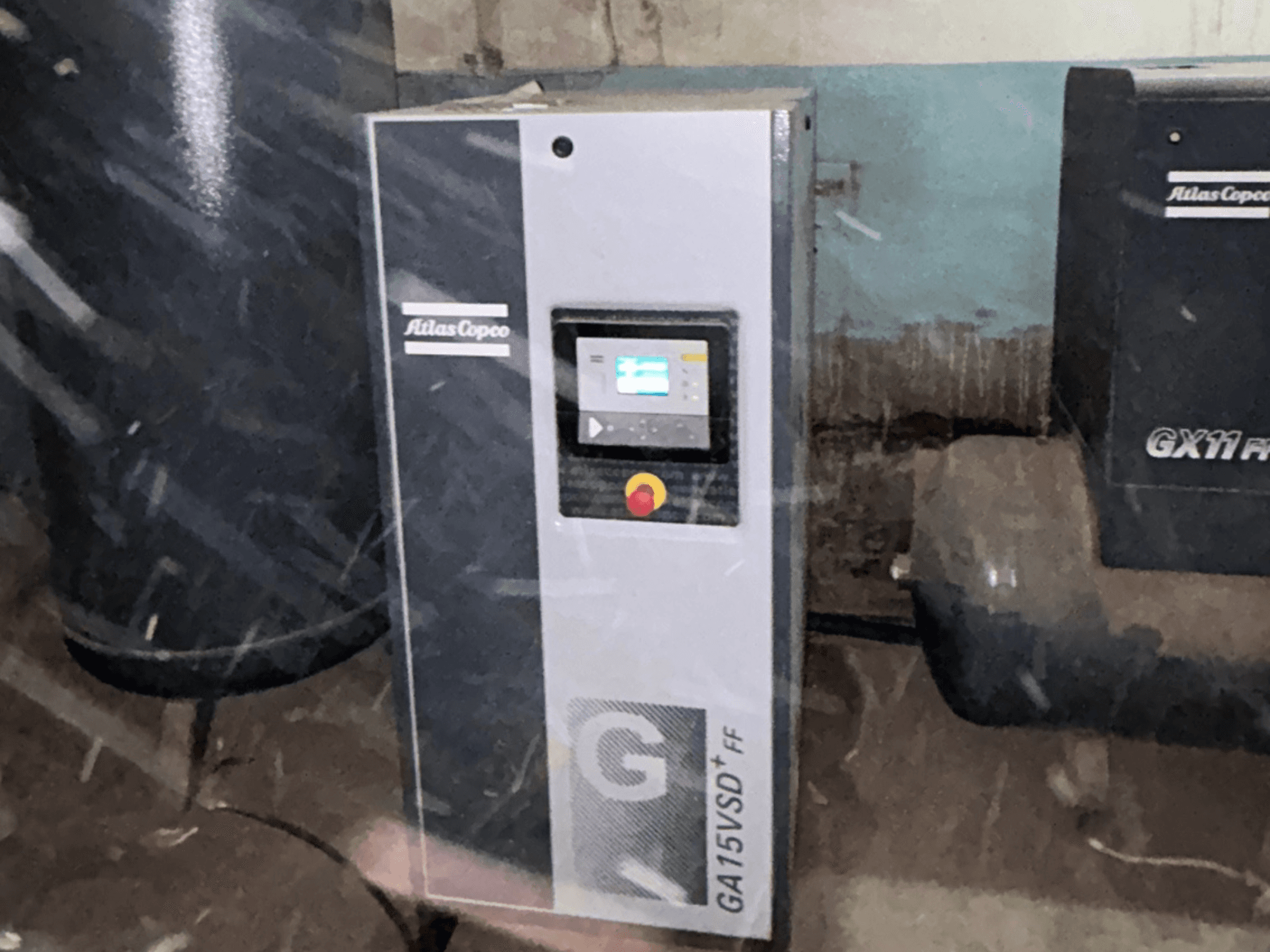 Atlas Copco GA15VSD+FF air compressor, front view, includes control panel with display and red emergency stop button.