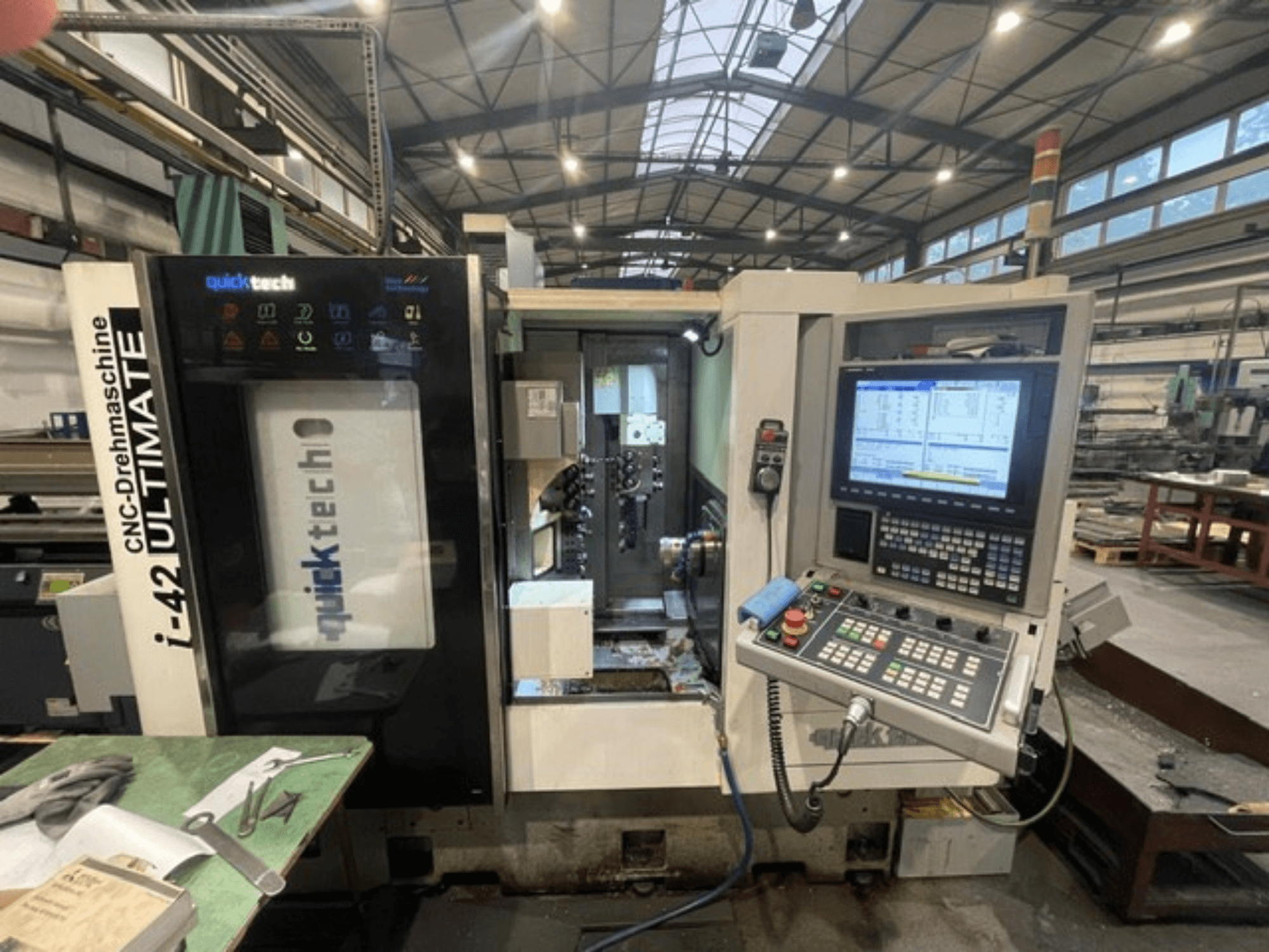 Quick-Tech I-42U Swiss Type Turning Machine, front view, showcasing control panel and CNC interface in a workshop setting.