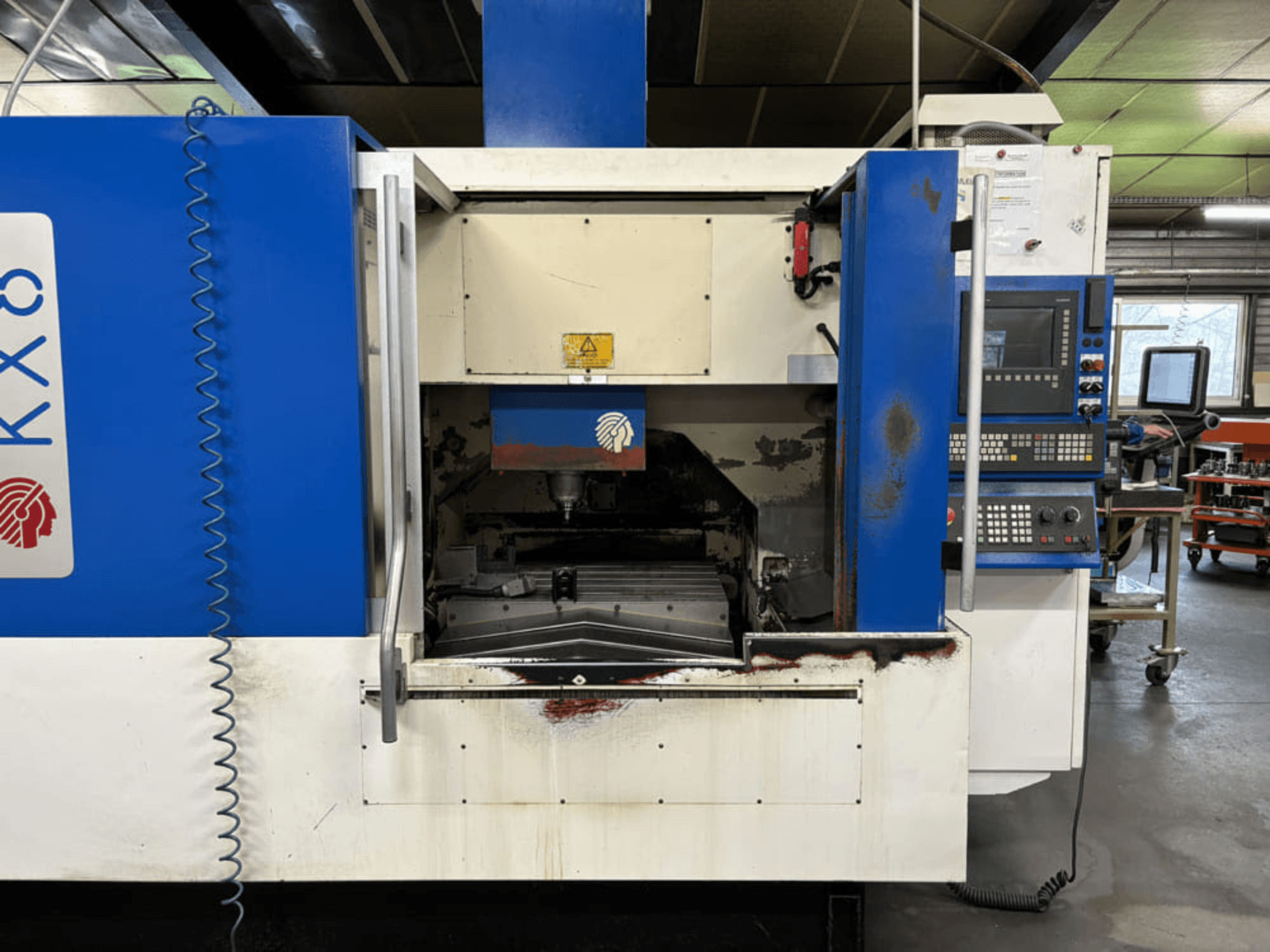 Huron KX8 vertical machining center, front view, showcasing open door, machining area, and control panel with keyboard.
