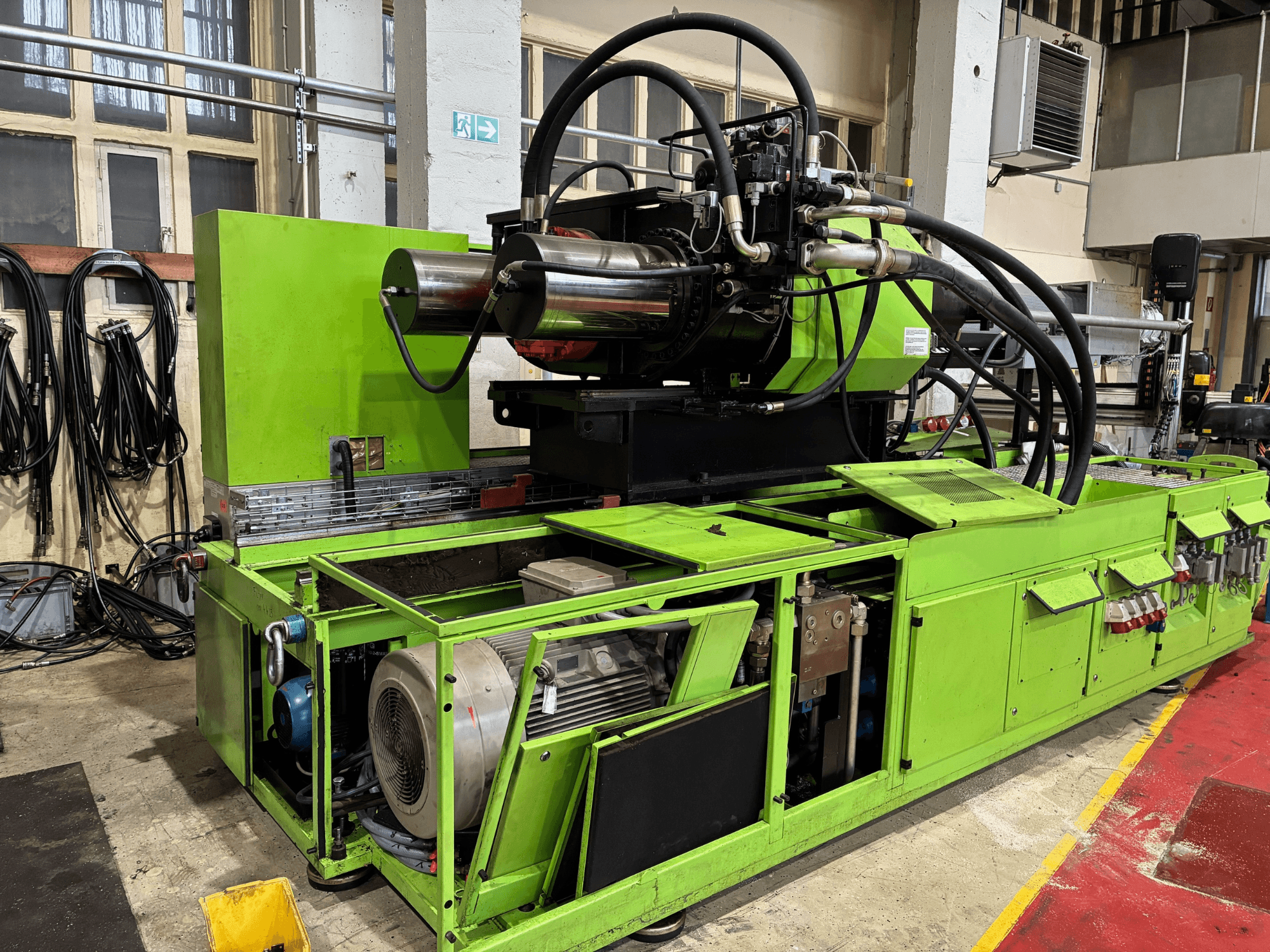 Green industrial machine with hydraulic system, front view, showing motor and various control panels.
