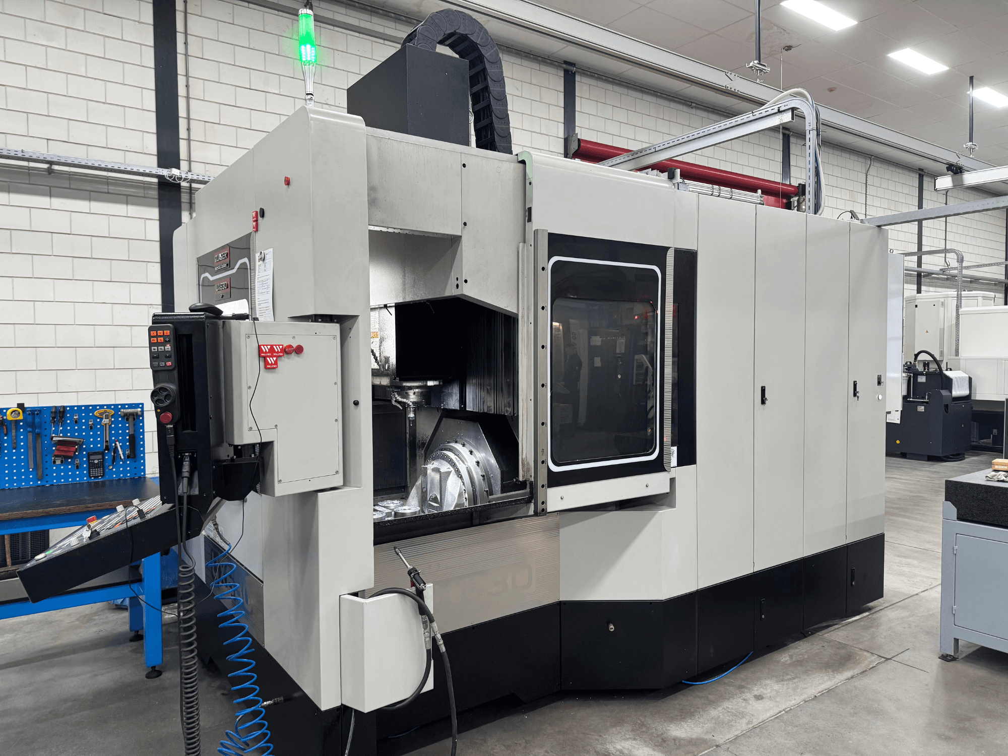 Quaser UX630 Universal Machining Centre in a workshop, front view with control panel and green indicator light visible.