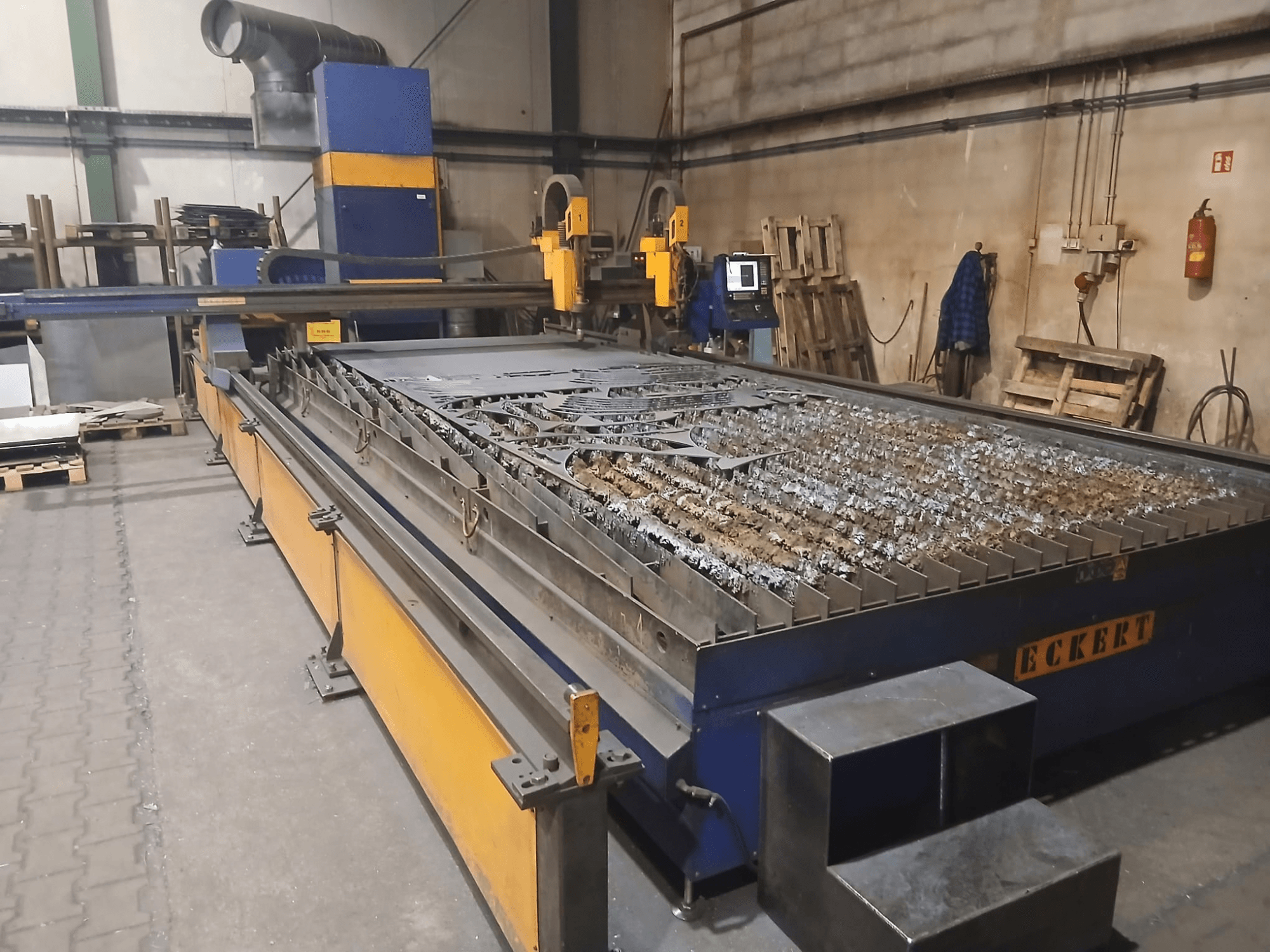 Plasma cutting machine ECKERT JANTAR 2 in front view, featuring a large cutting table with metal pieces and operational controls.