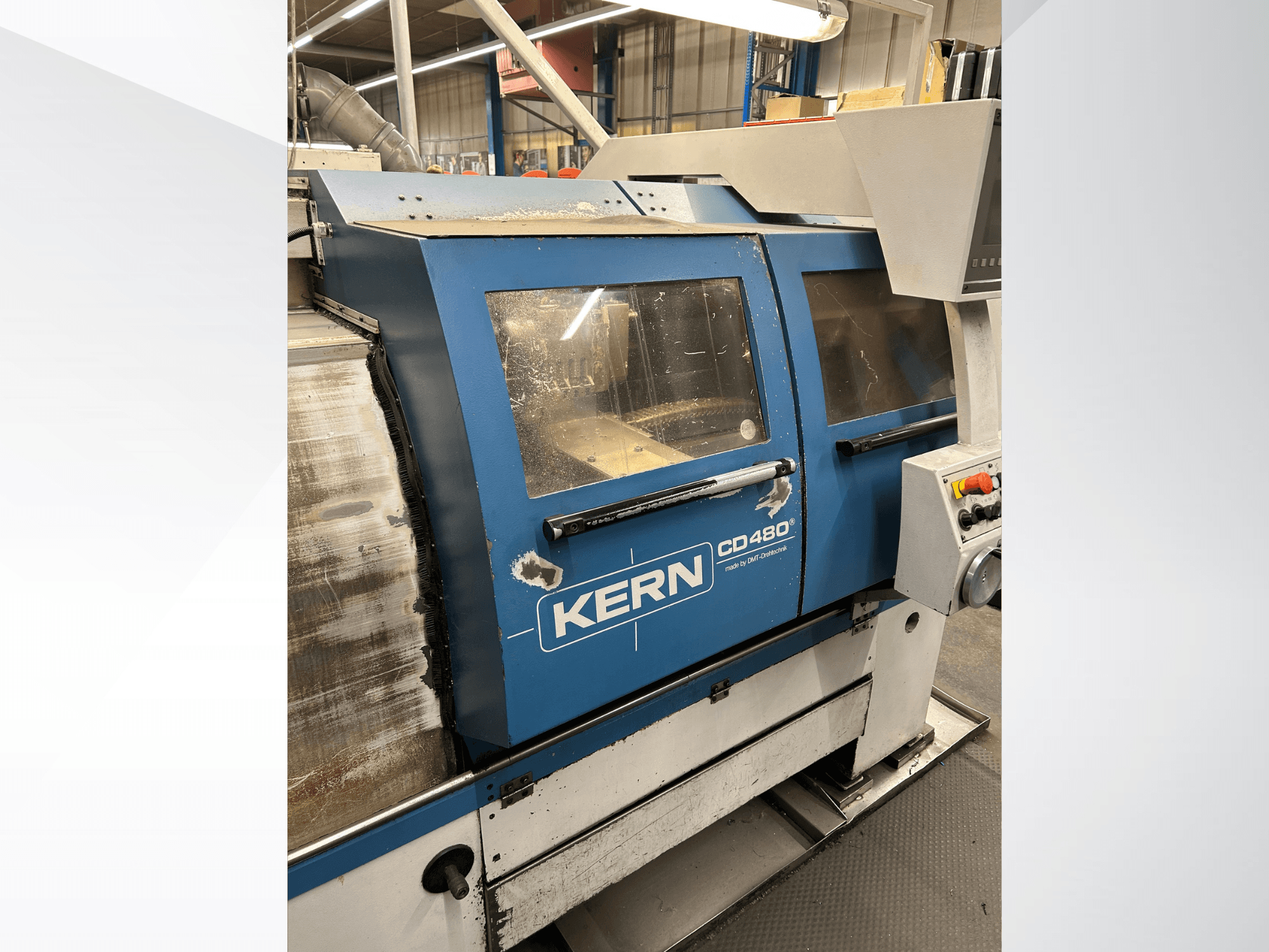 DMT Kern CD480 horizontal turning machine, side view featuring control panel, large windows, and metal casing.