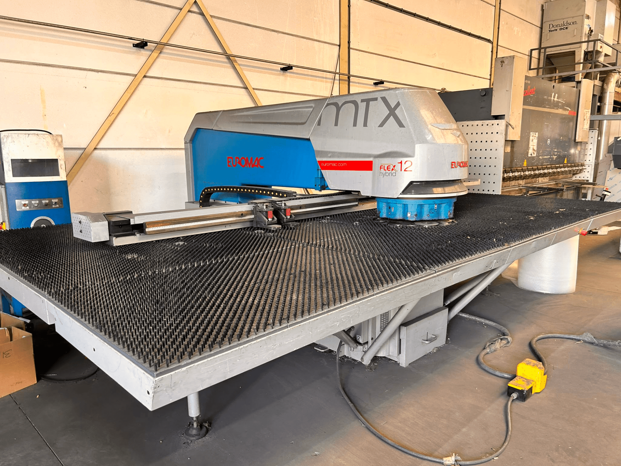 Euromac MTX FLEX 12 CNC punching machine, front view, featuring a large perforated table and control panel.