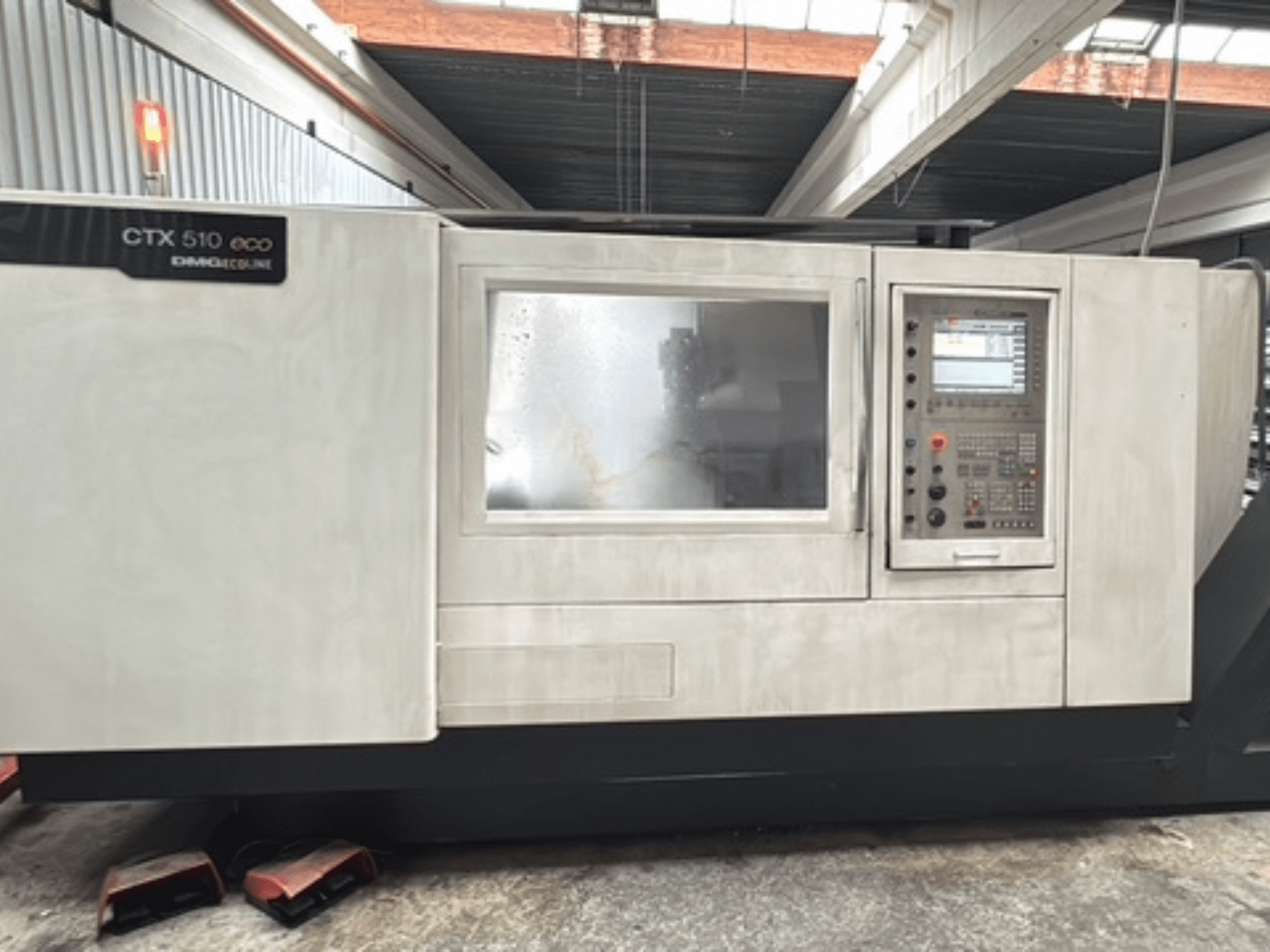 Horizontal turning machine DMG CTX 510 ecoline, front view, showcasing control panel and window on the machine body.